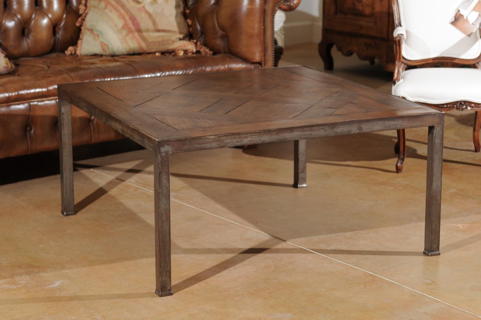 A French coffee table from the 20th century made of antique walnut parquet top and iron base. This French square shaped coffee table is made of an antique walnut parquet top secured in a sturdy custom made iron base. The top reveals the pattern