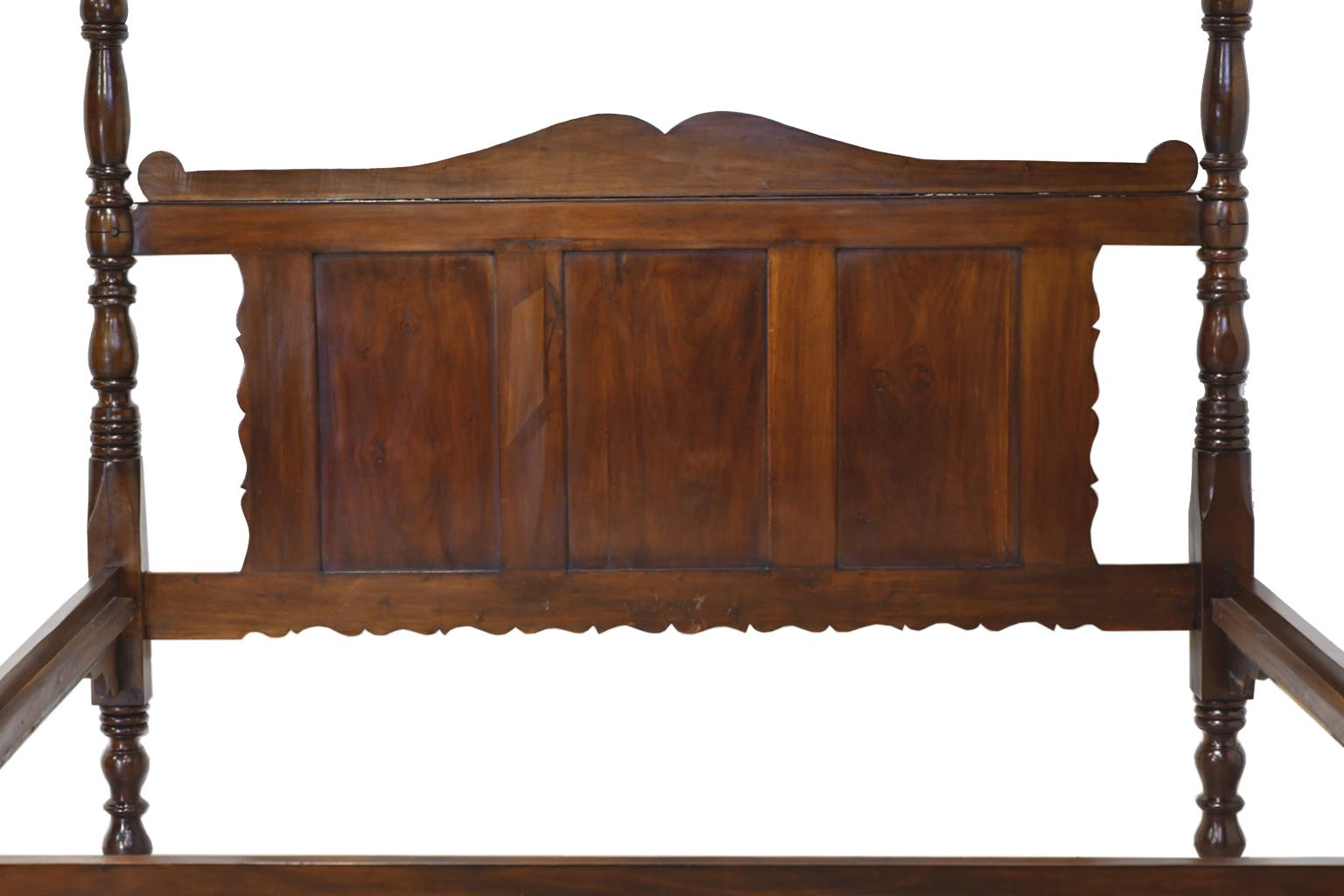 A very beautiful French Colonial bed in West Indies walnut with turned posts and paneled headboard with double-arched pediment top and scalloped sides. Likely from Haiti, circa 1830.
This early 19th century Caribbean four poster bed was purchased in