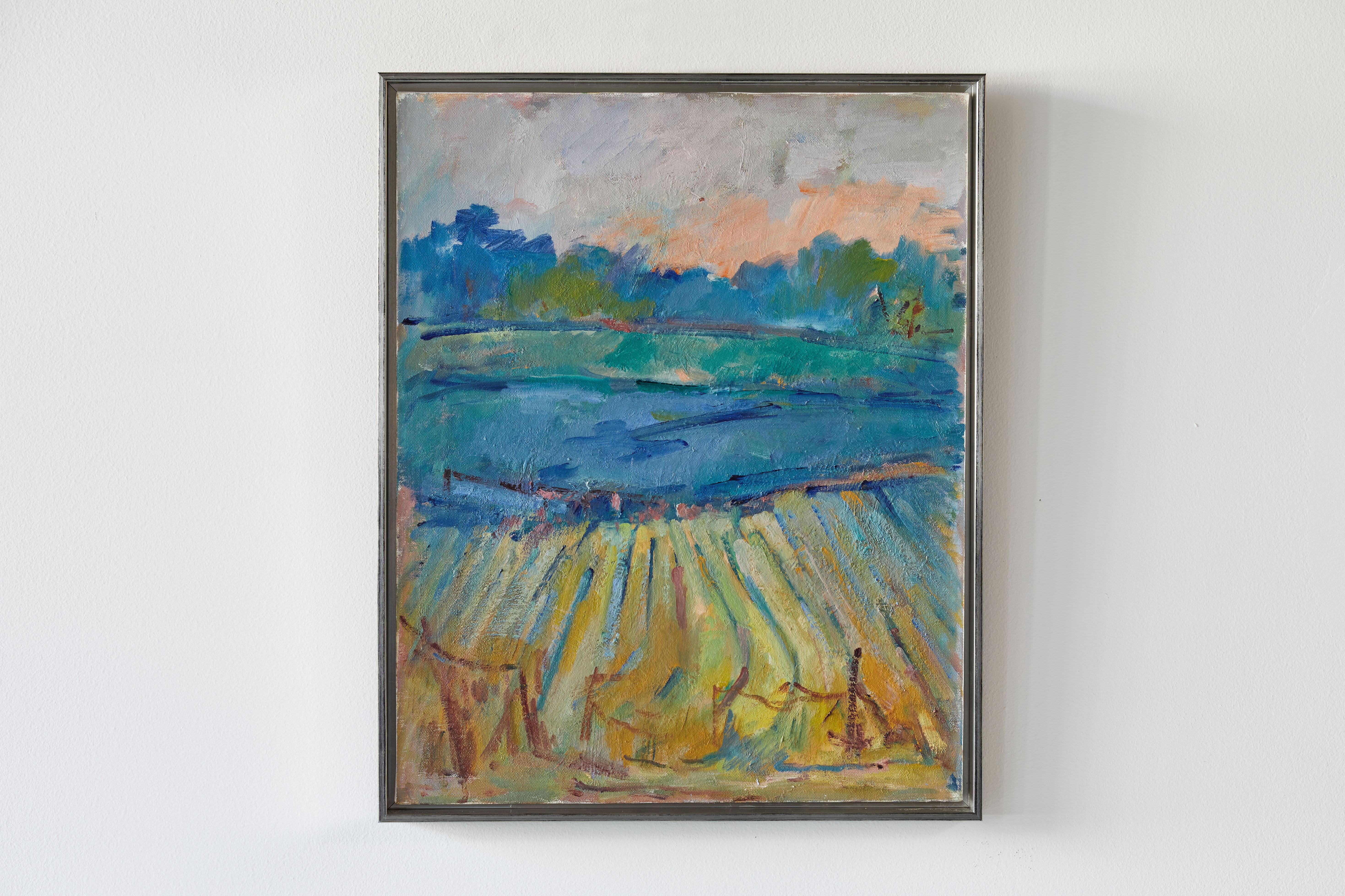 French colorful painting of the countryside with hues of blues, yellows, pinks. The painting is newly framed in a silver frame.