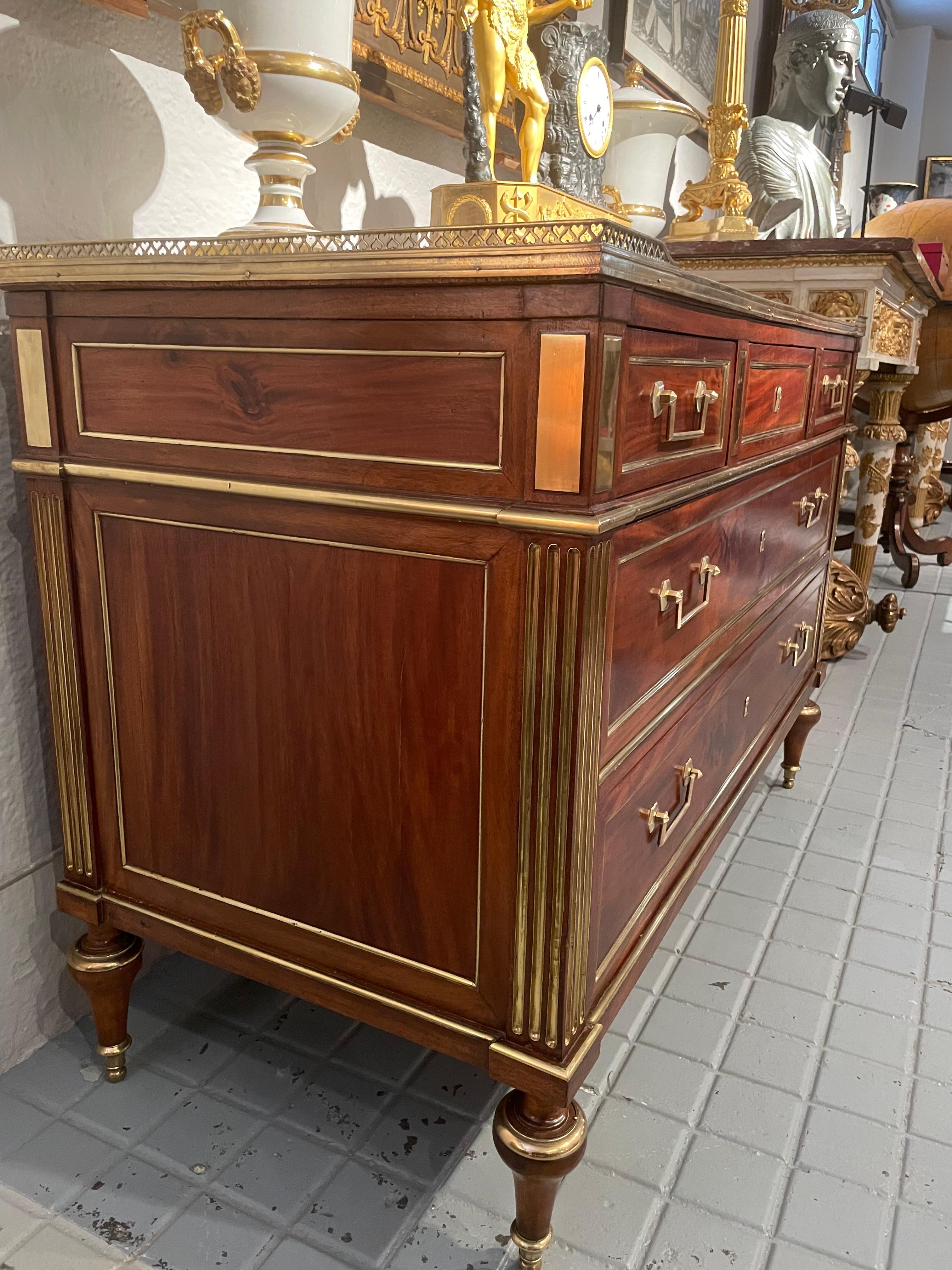French Commode in mahogany with rich ornamentation in bronze and gilded brass, topped with veined withe marble and open brass gallery. 
Louis XVl Period at the end of eighteen century.