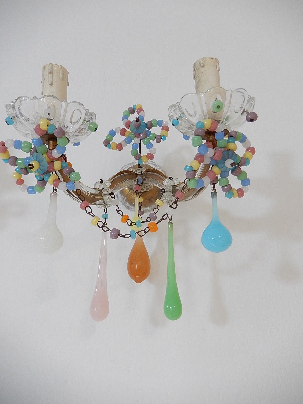 Will be re-wired with appropriate sockets for the country and ready to hang! Housing two lights each, sitting in crystal bobeches with opaline beads. Adorning rare opaline drops in different colors and swags of macaroni beads in opaline as well.