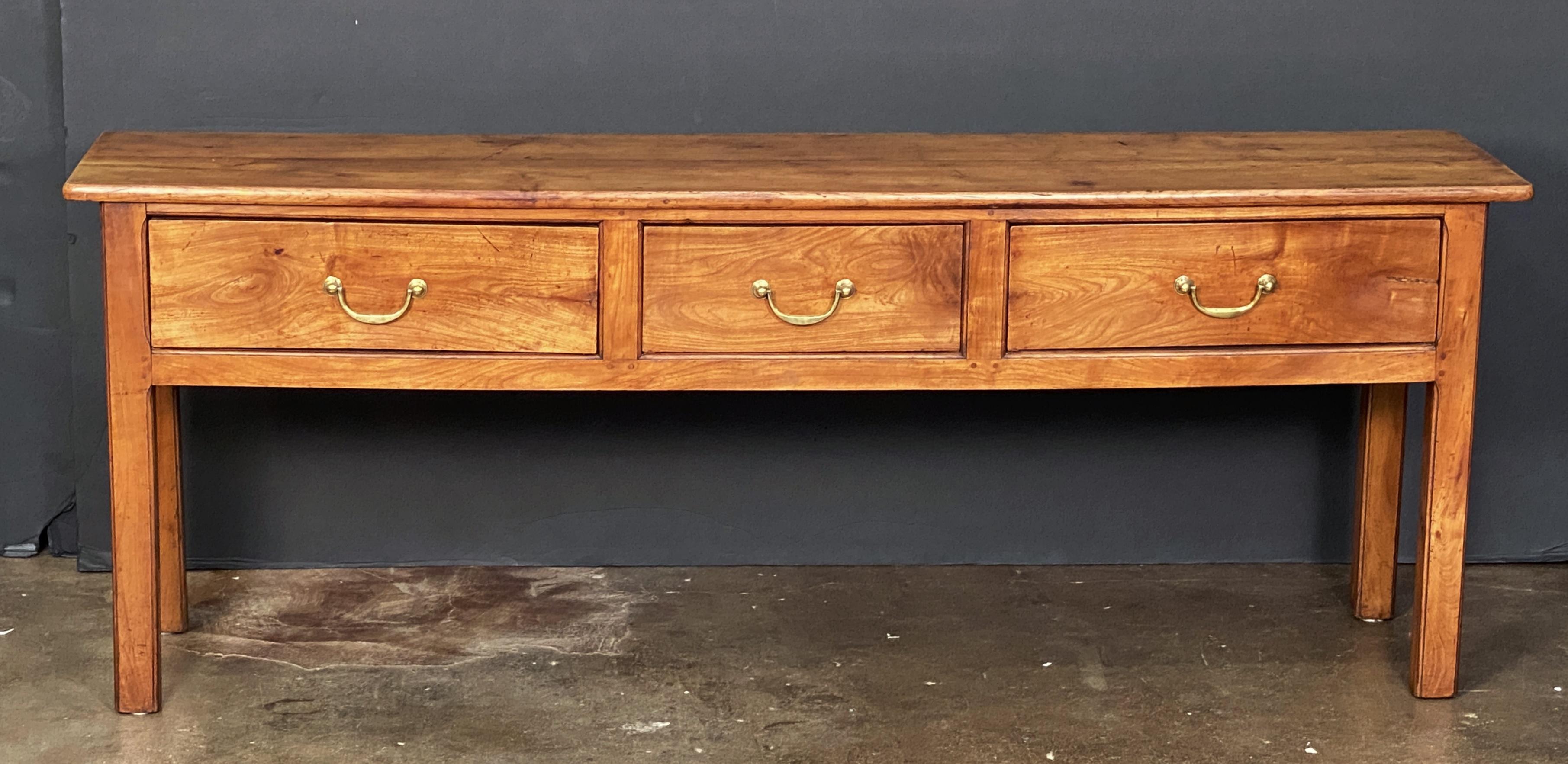 Beau buffet (ou table de service) français en merisier patiné, comprenant un plateau rectangulaire sur une frise avec trois tiroirs, chacun avec des poignées en laiton, un dos et des côtés lambrissés, et reposant sur des pieds carrés.

H 30 in x W