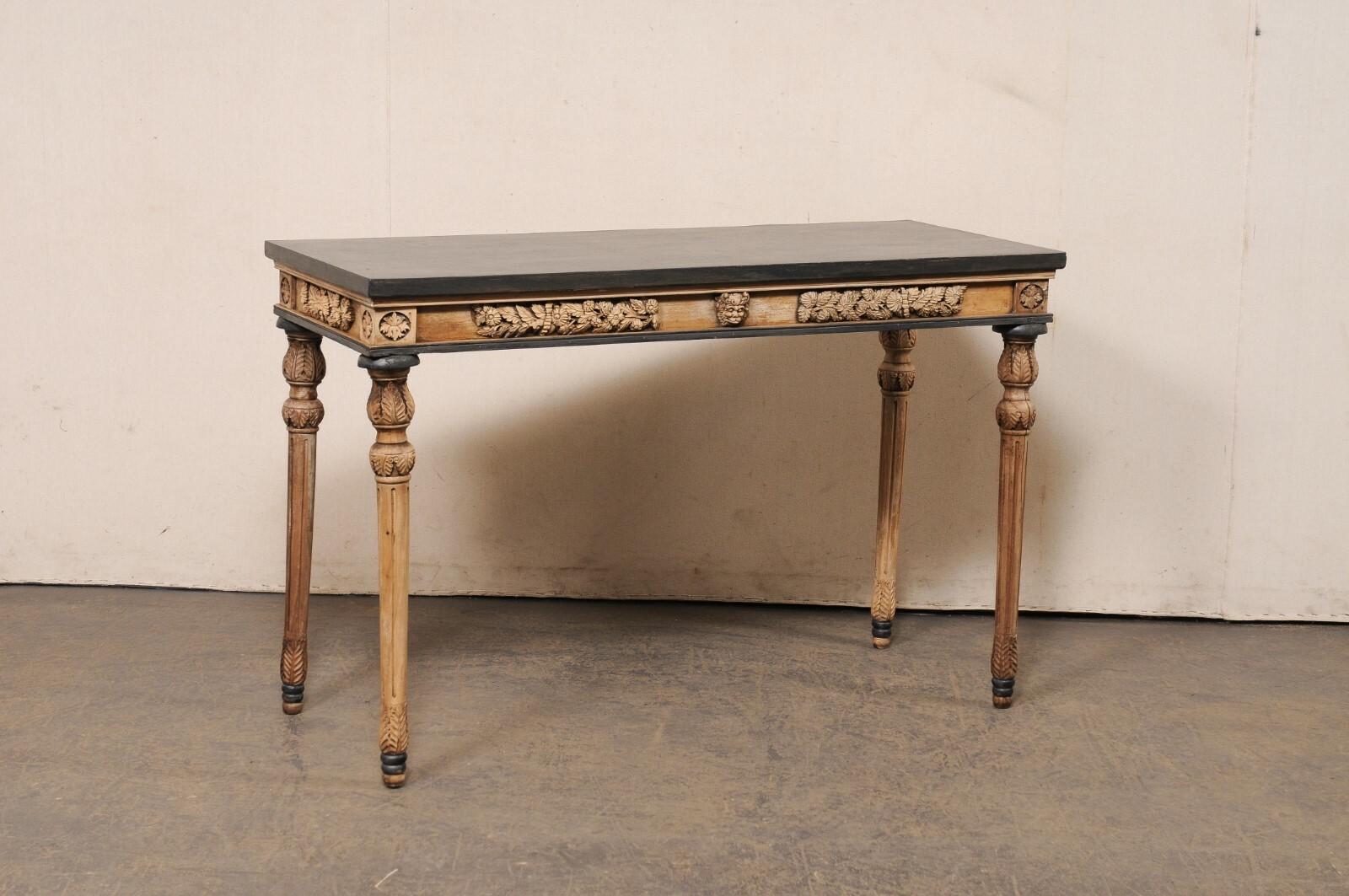 A French carved and painted wood console table. This vintage table from France has a 4.5 foot long rectangular-shaped top, with apron below carved on all four sides (giving this piece the ability to be floated within a room) in a beautiful floral