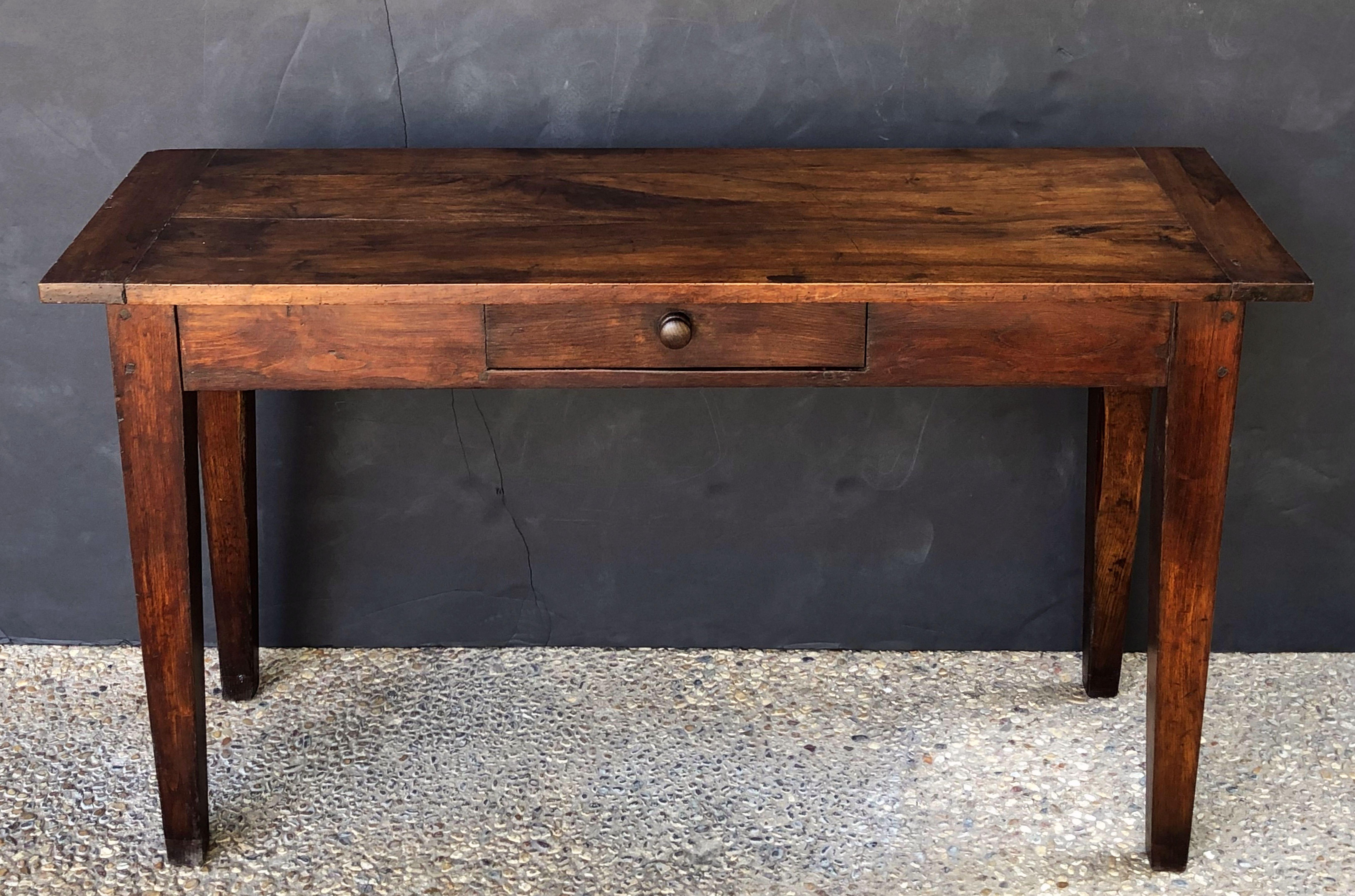 A fine French console sideboard (or serving table) of walnut, featuring a flat rectangular plank top over a frieze with one drawer, drawer with knob pull of turned wood, standing on tapering legs.