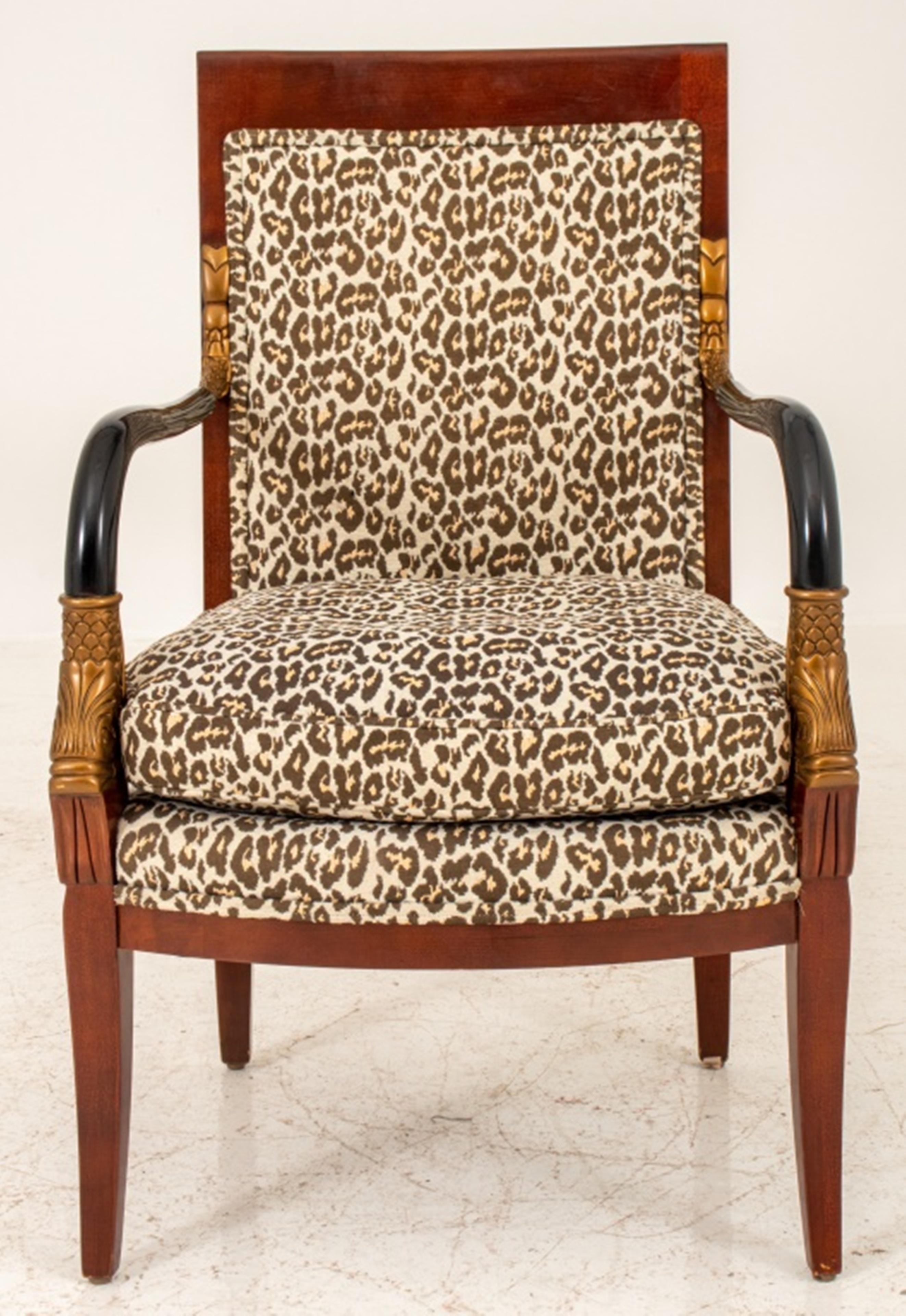 French Consulate style arm chair or fauteuil a la reine with rectangular mahogany crestrail and down-swept arms ending in gold-painted dolphin terminals, above a shaoed seatrail on sabre legs, upholstered in leopard jacquard. 


Dealer: S138XX.