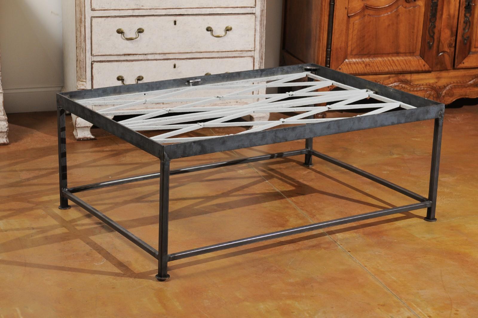 A French contemporary coffee table made from 18th century cast iron railings. Featuring a linear silhouette, this contemporary French coffee table showcases a pierced top made from 18th century cast iron painted railings with diamond patterns