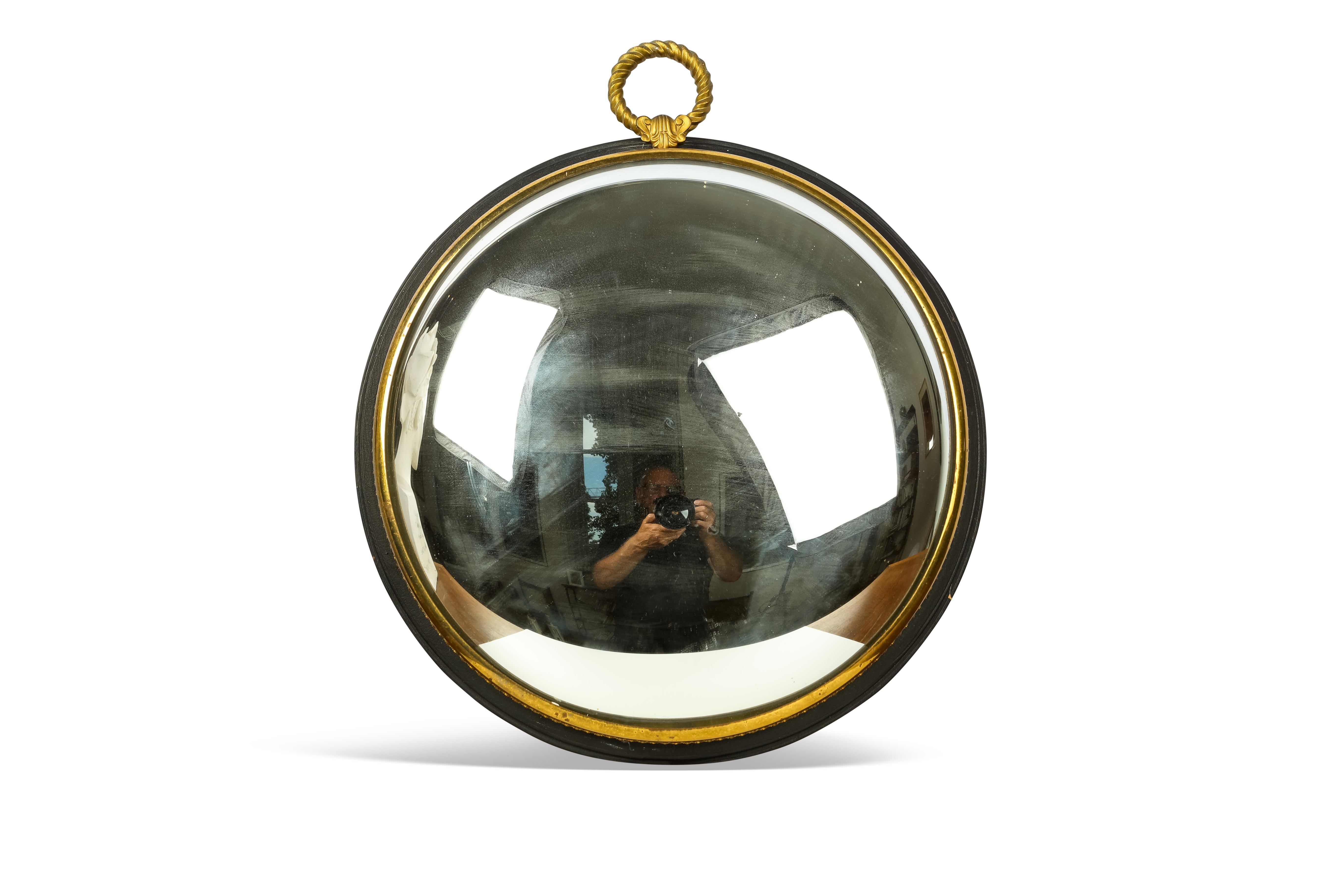 This French 19th century convex mirror is on a black wood base, surrounded by a wide ornate brass ring. The eye with a rope pattern is also in brass. The whole  convex mirror has a very elegant shape.
On the convex surface there are 4 very small
