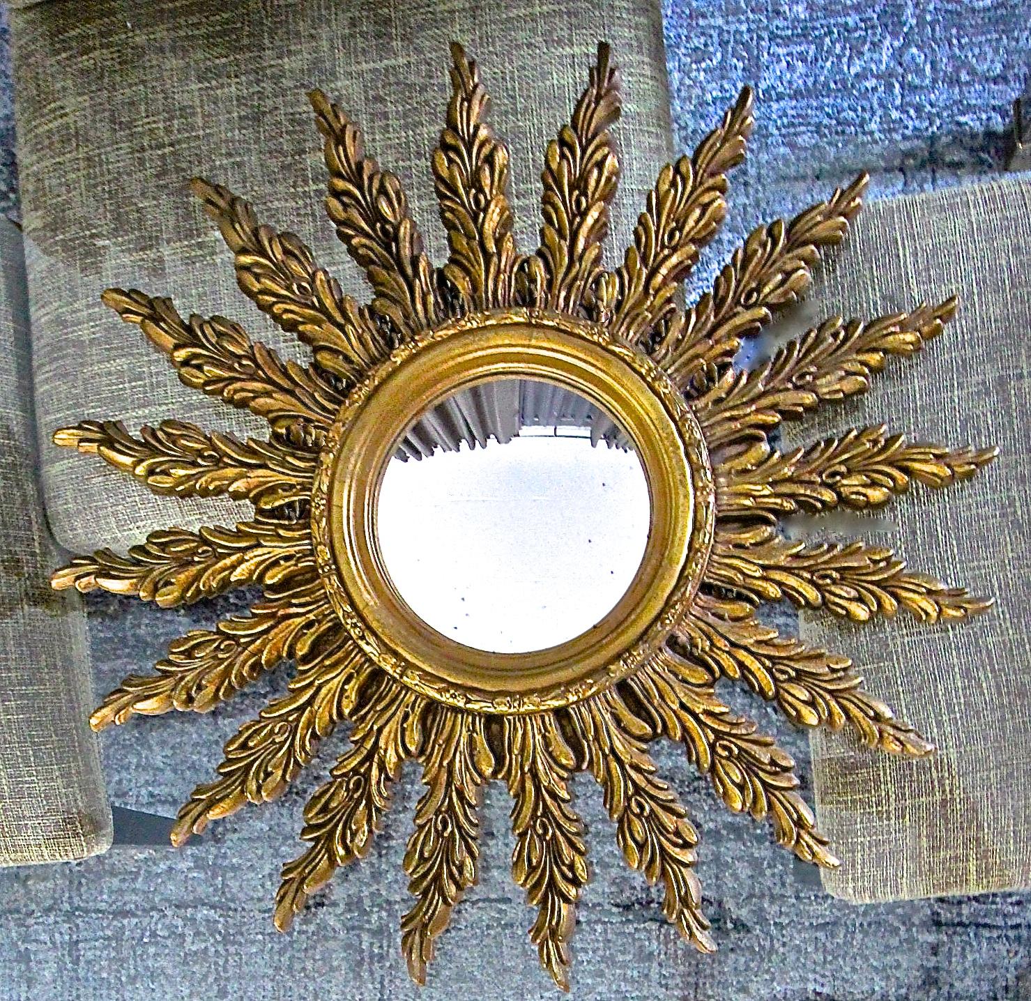 French round gilt wood sunburst or starburst wall mirror with antiqued convex mirror. Wall mirror is combination of composition and wood. Overall diameter of mirror 25.5