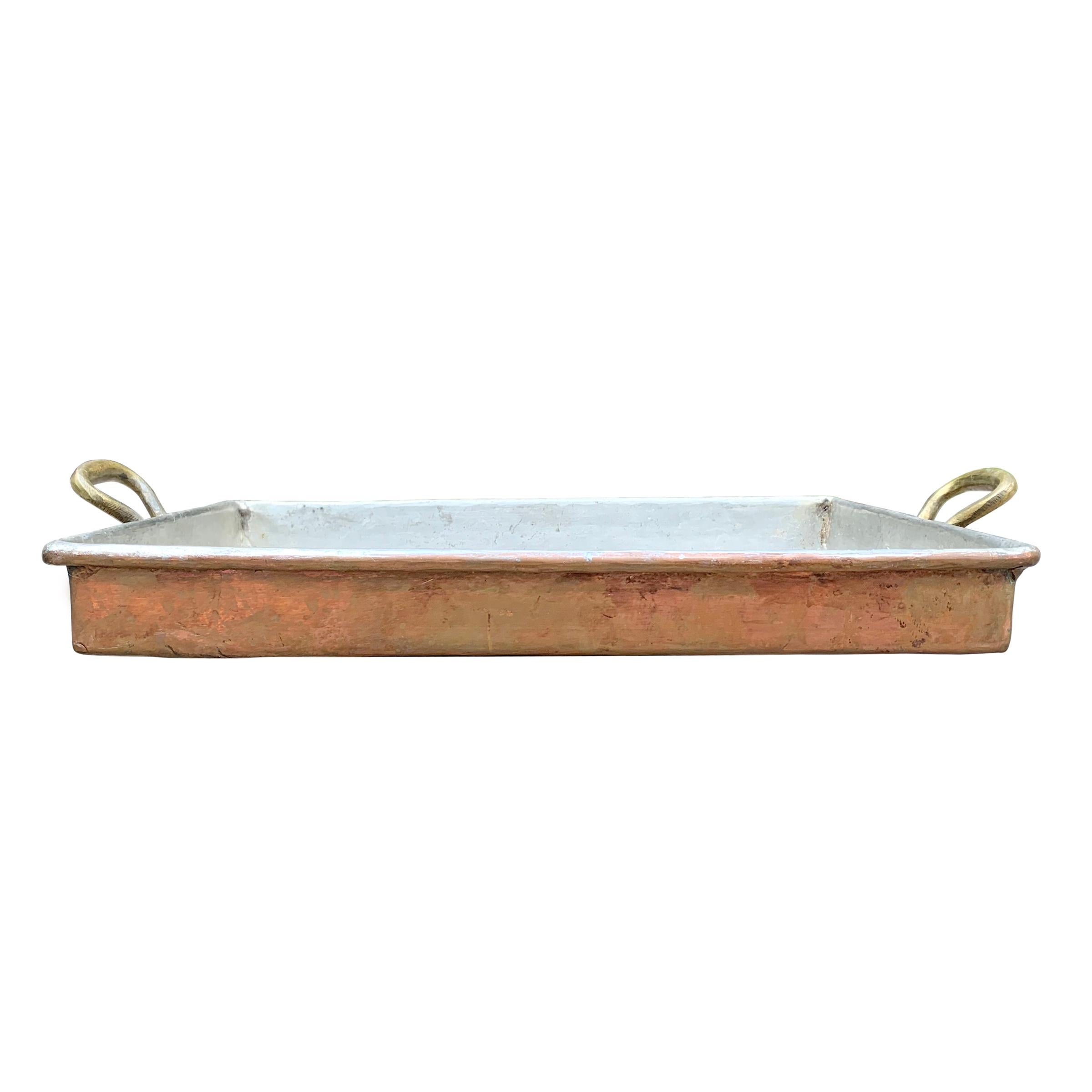 A fantastic mid-20th century French copper roasting pan with a rolled edge, tin lining, and heavy bronze handles, perfect for your next Sunday roast or Thanksgiving turkey. Pan is ready to use, but we are happy to polish and re-tin for an additional