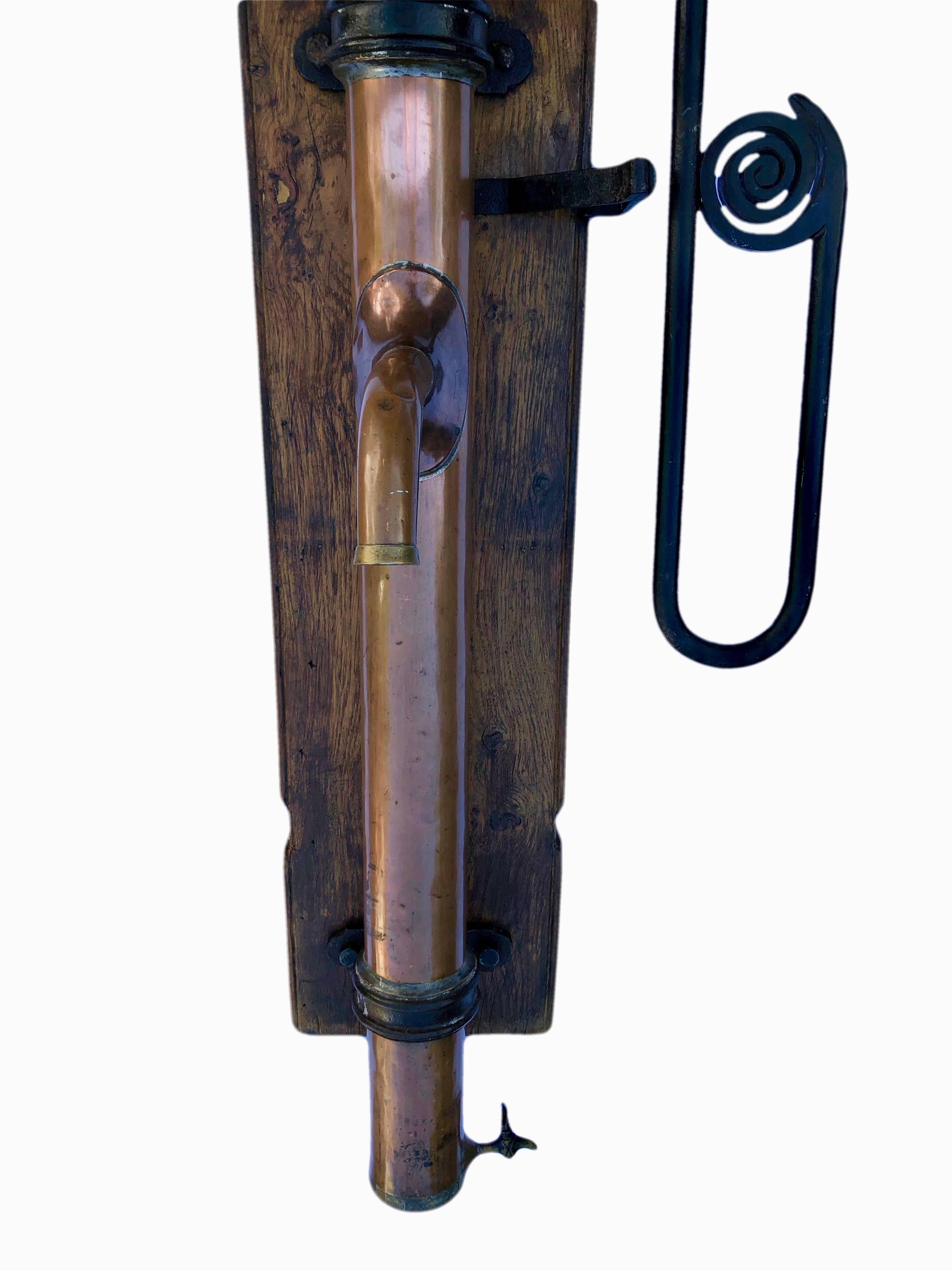 This is a rare French copper water hand pump Louis XIVth. It was originally used in a French castle kitchen. It has black iron accents and is mounted on a large old wood plank. It is a stunning piece that can still be used as a water pump today,