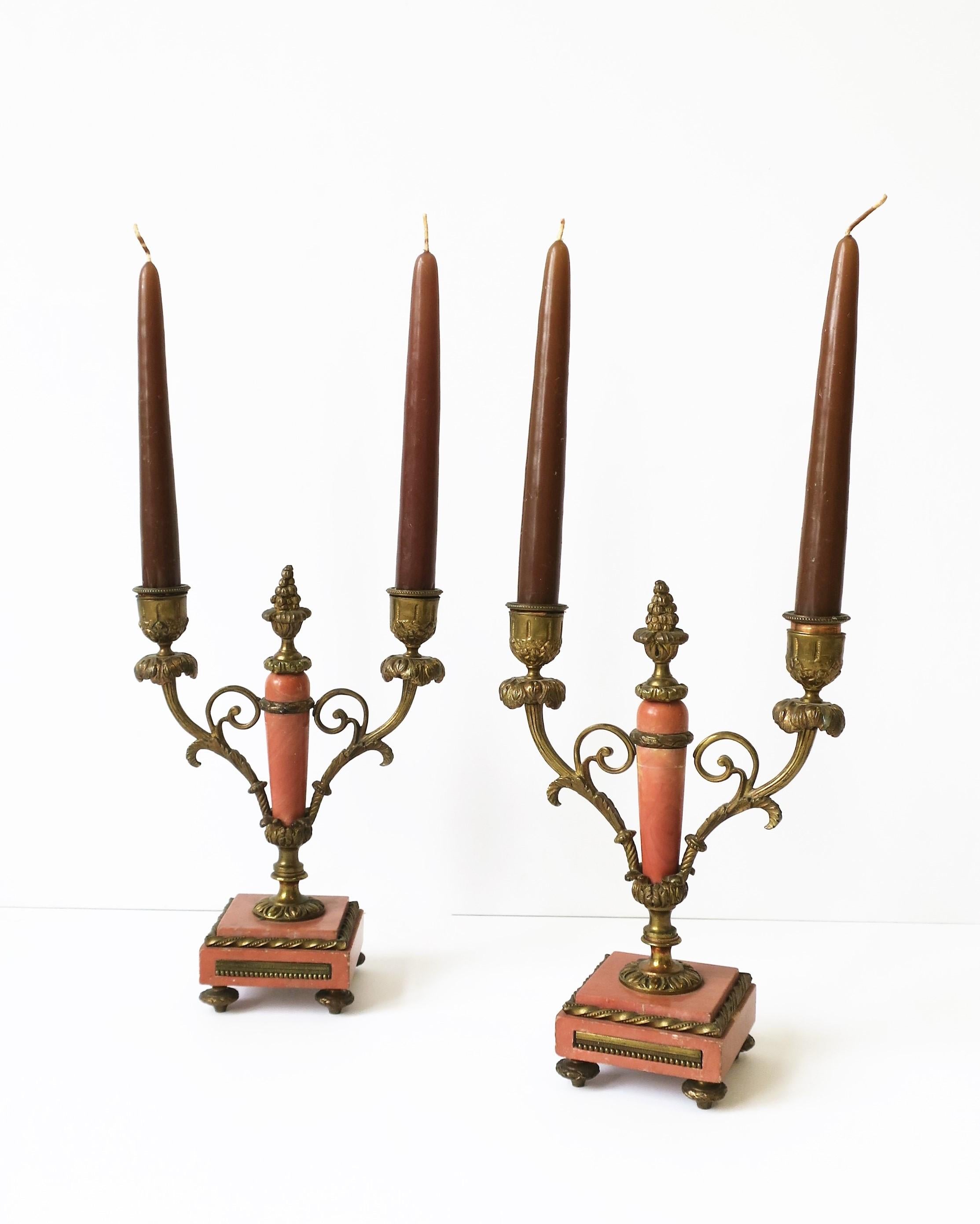 A beautiful pair of antique French salmon coral hue marble and gold brass ormolu candlestick or candelabra holders in the Louis XVI style, circa late-19th century, France. Marble is a salmon/coral hue. Marked 