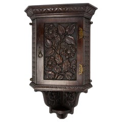 Armoire murale d'angle en châtaignier à sculptures florales, circa 1900
