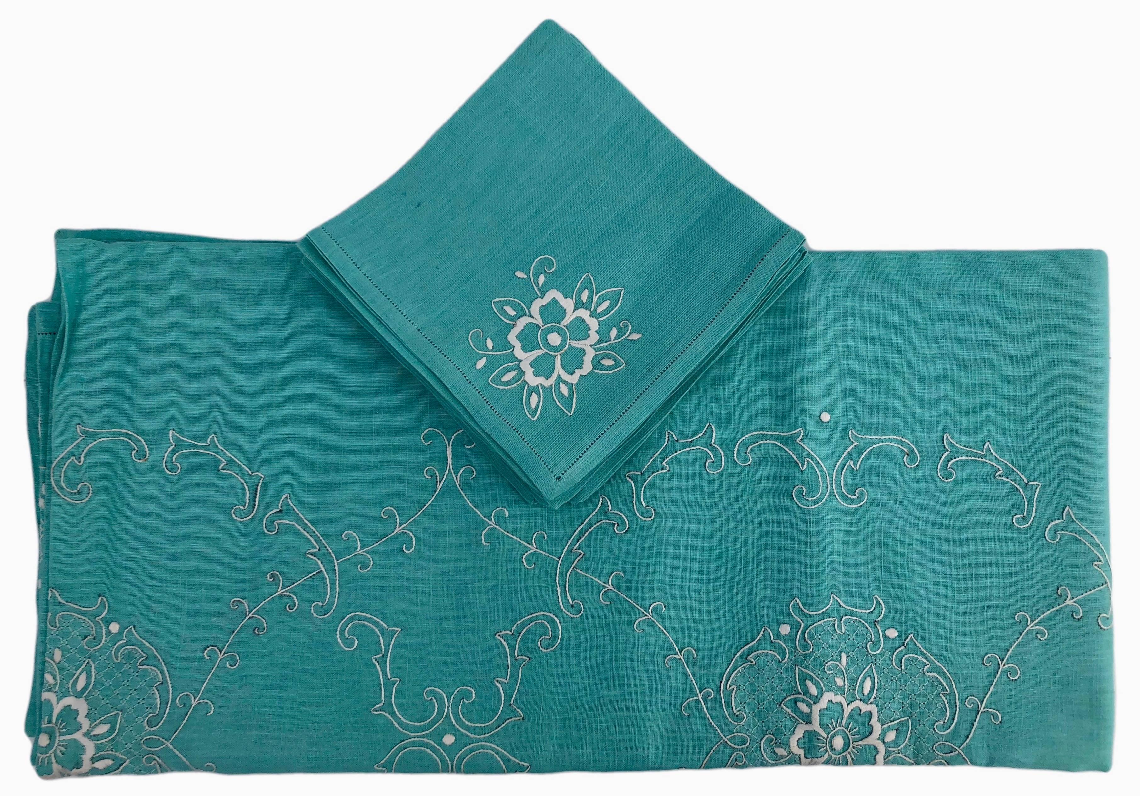 This is a lovely French cotton turquoise tablecloth with white embroidered flowers and a scroll design throughout. There are also eight matching napkins with the same design. The embroidered flowers have a thicker white embroidery design while the