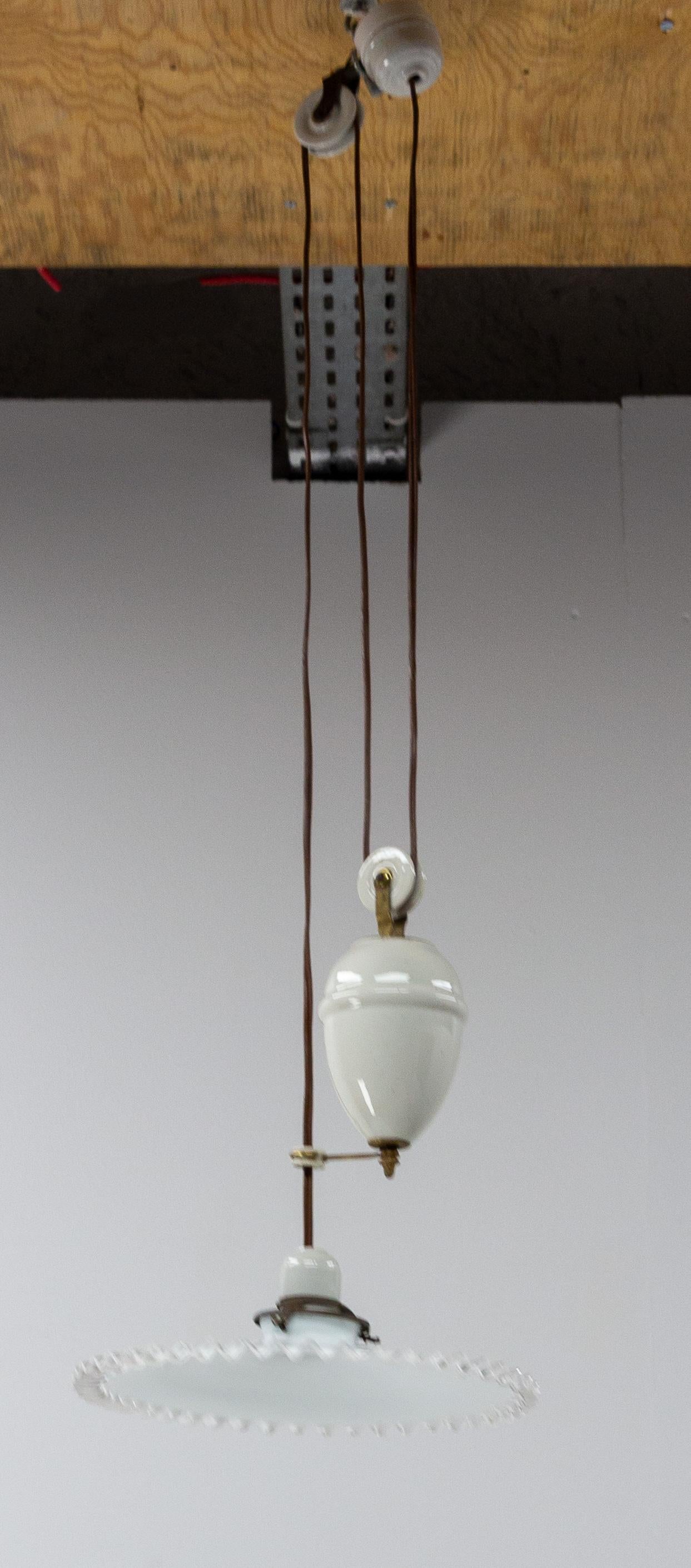 Ceiling pendant lamp in glass and opaline early 20th century.
French counter weight chandelier. White glass diffuser and porcelain weight for adjusting the overall length.
This lustre makes a nice shadow on the walls of the room when it is