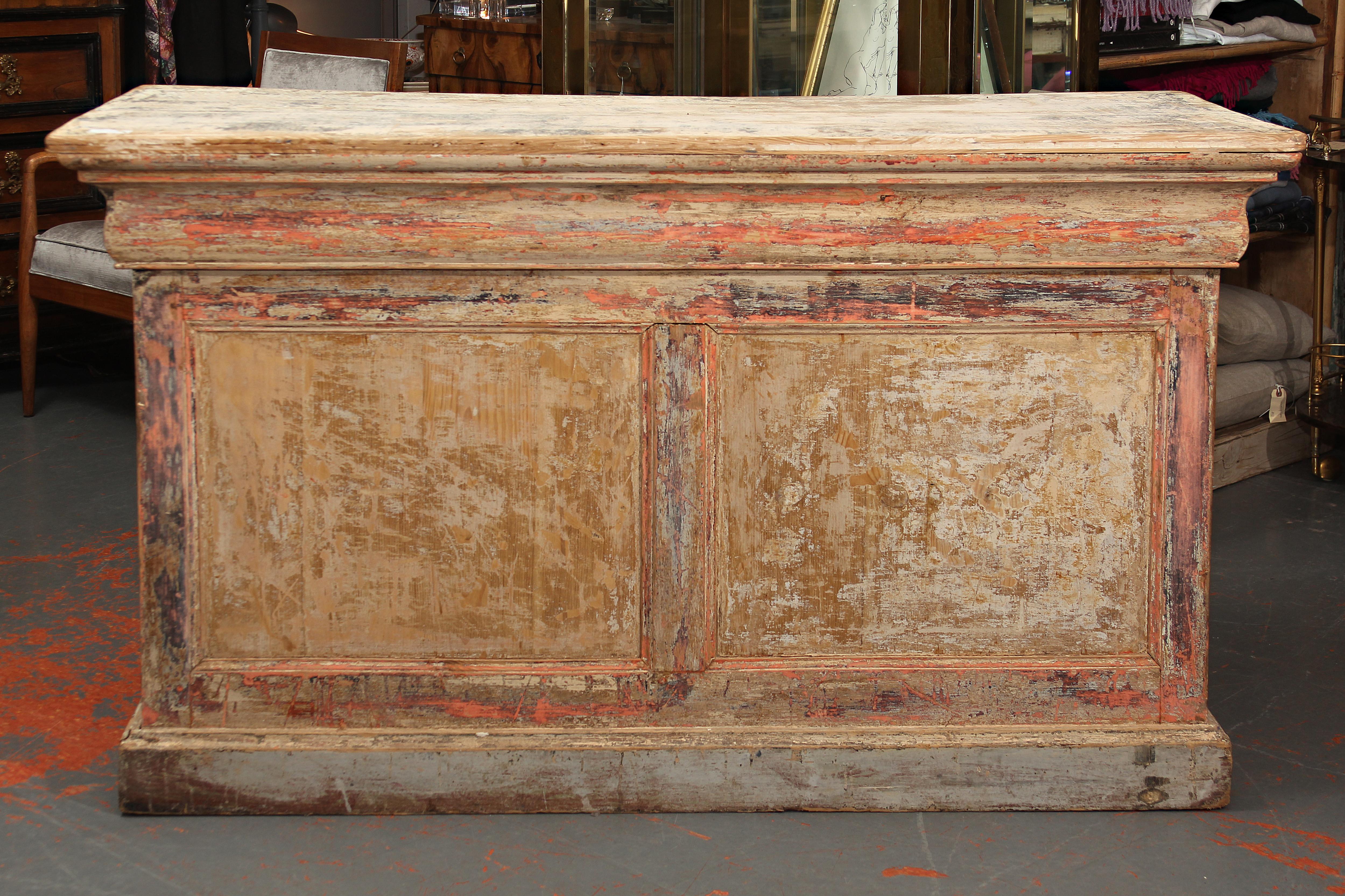 Very functional store counter from France. Layers of paint have been stripped away, many drawers. Would make a great kitchen island or console as well as a perfect check-out counter for a retail setting