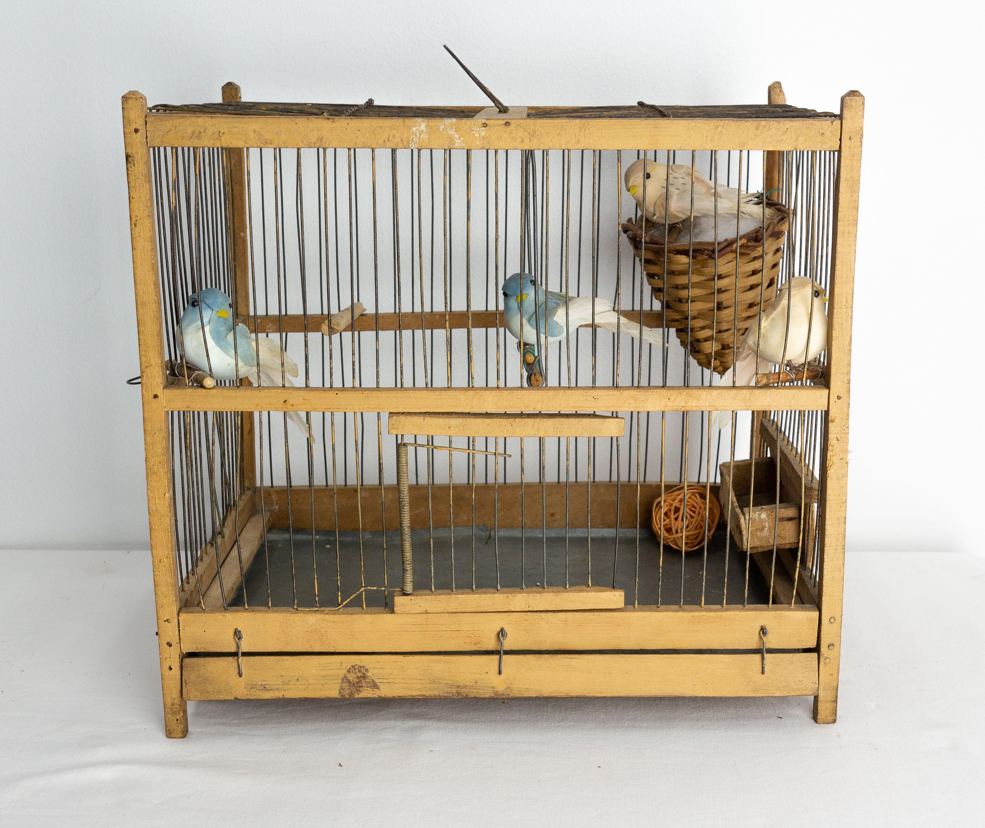 Cage à oiseaux française décorée d'oiseaux.
Au fond de la cage est placé un plateau en zinc pour faciliter le nettoyage. Une mangeoire est amovible, ce qui permet de nourrir les oiseaux sans les déranger.
La décoration a été ajoutée récemment et