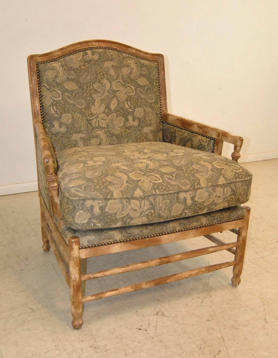 A unique French country Bergere style armchair by Isenhour Furniture. The chair is upholstered in a rich taupe cloth with tone on tone grape vine pattern (a match to a Baker Sofa we have listed separately). The chair features a distressed lime