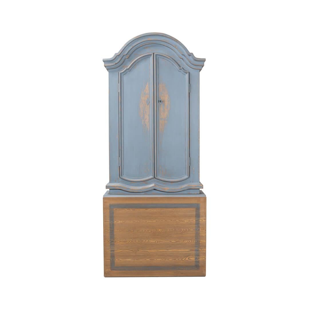 Antiqued blue painted secretary bookcase with an unusual folding writing surface that can convert to a table. It features a beautiful molded bonnet at the top. The upper cabinet has adjustable shelves and the sides of the cabinet have two small