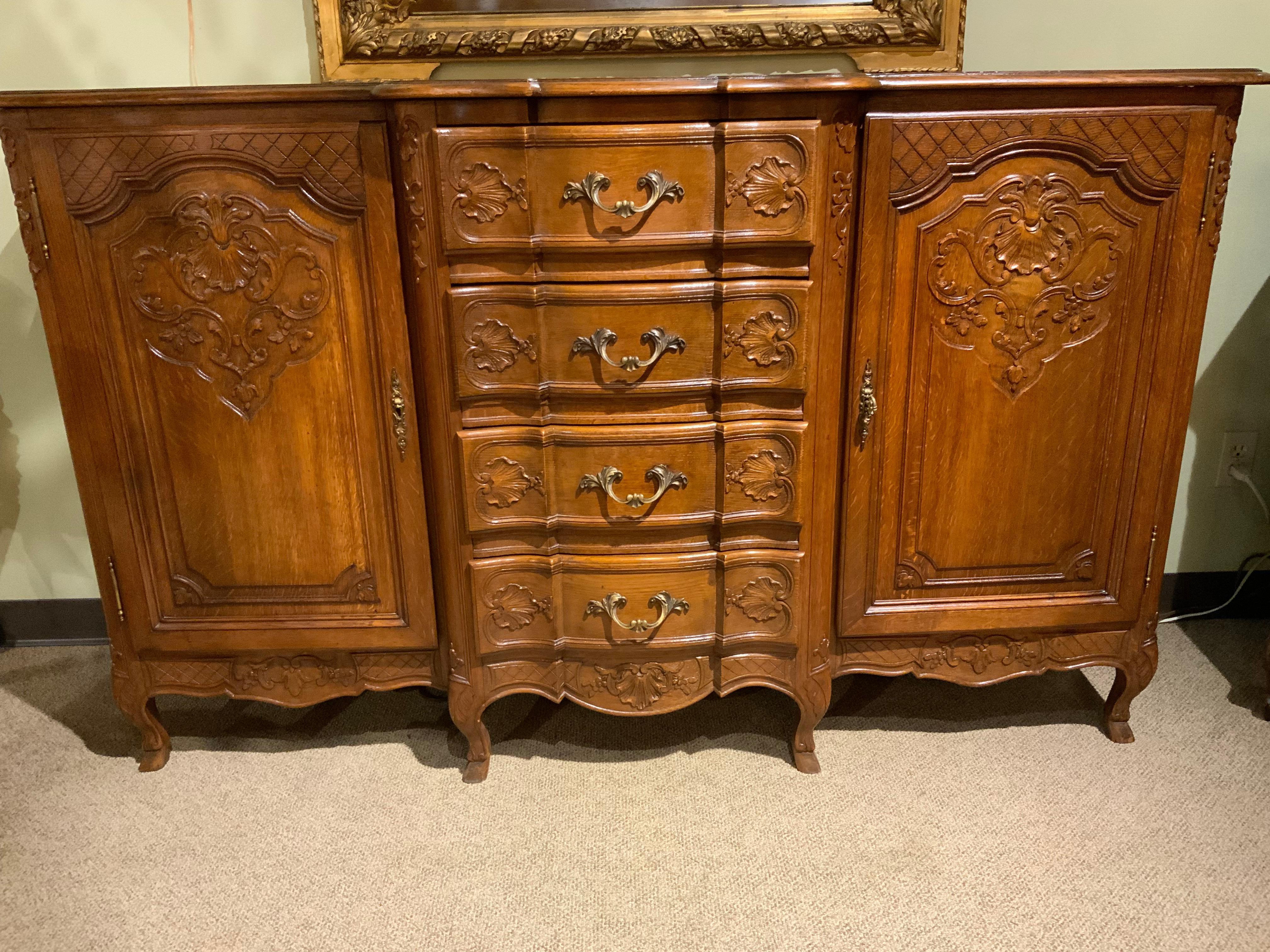 The exceptional condition and carving make this piece
Unique. It has four drawers down the center for good storage 
And cabinets on each side with doors that open to two
Shelves on each side. The patina is a warm rich hue in a
Fine oak finish. No