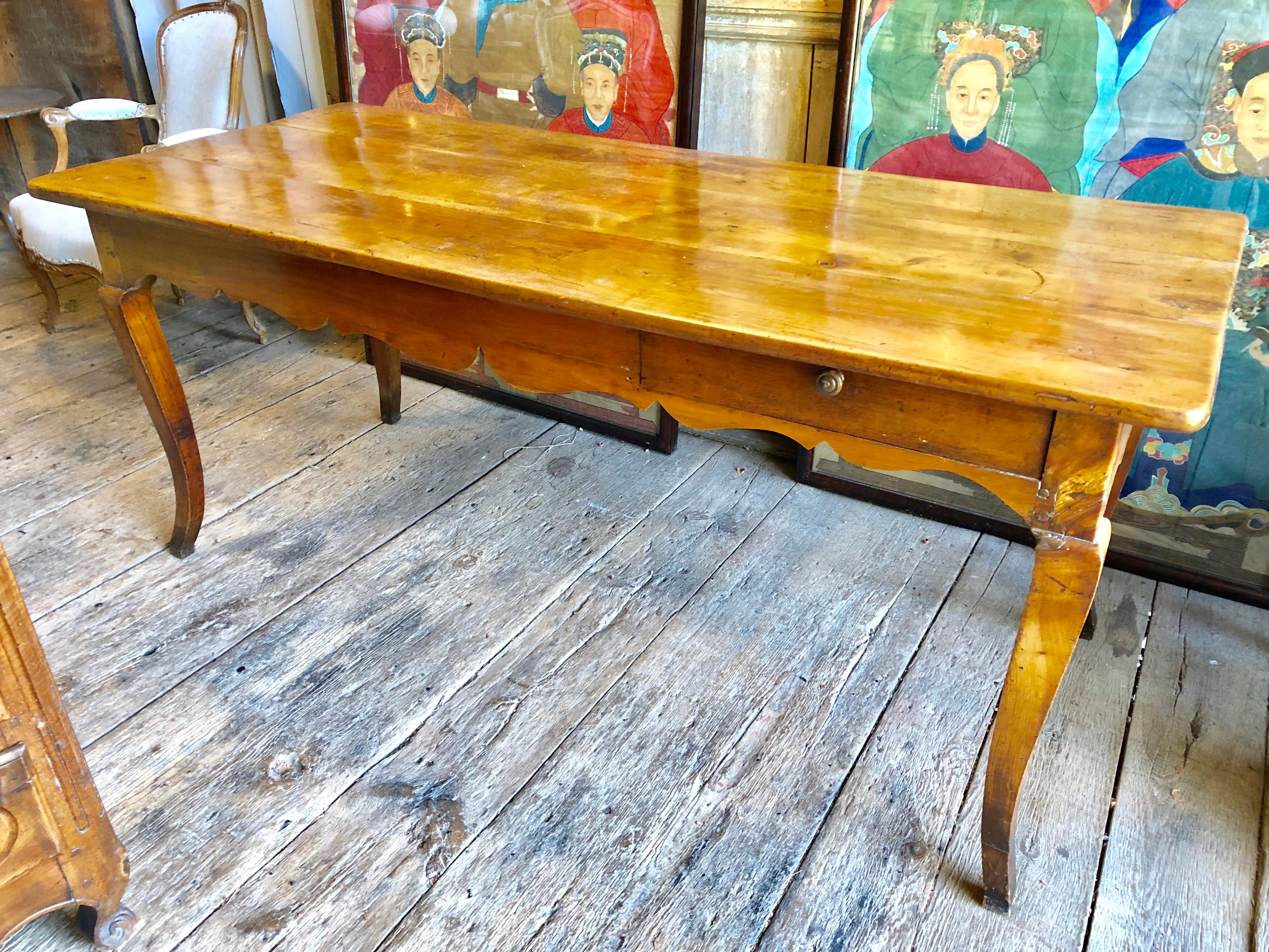 A beautiful French Country farm table, Louis XV period, circa 1770, in cherrywood, with a drawer on the side and cutting board on one end. Nice honey colored with old patina. Measure: Height to bottom of apron: 23.5”.