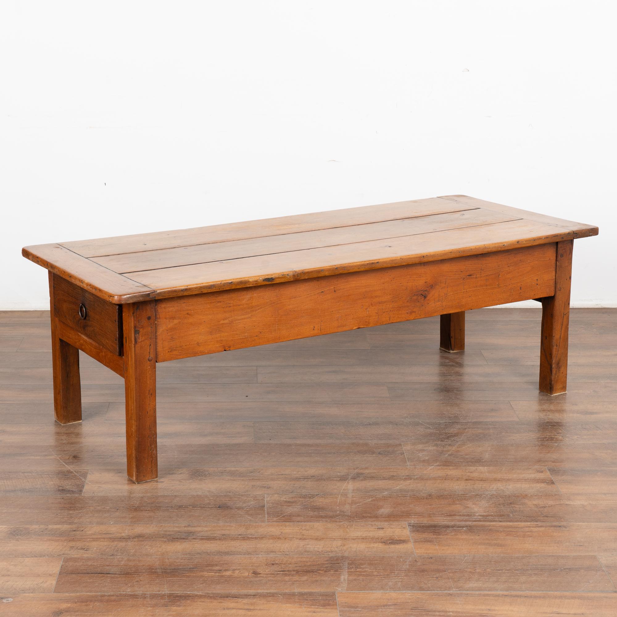 The lovely patina of the aged wood glows in this coffee table from France. Two long drawers accent each end.
Every scratch, nick, crack and aged separation of the three planks that comprise the top simply add to the vintage draw of this coffee