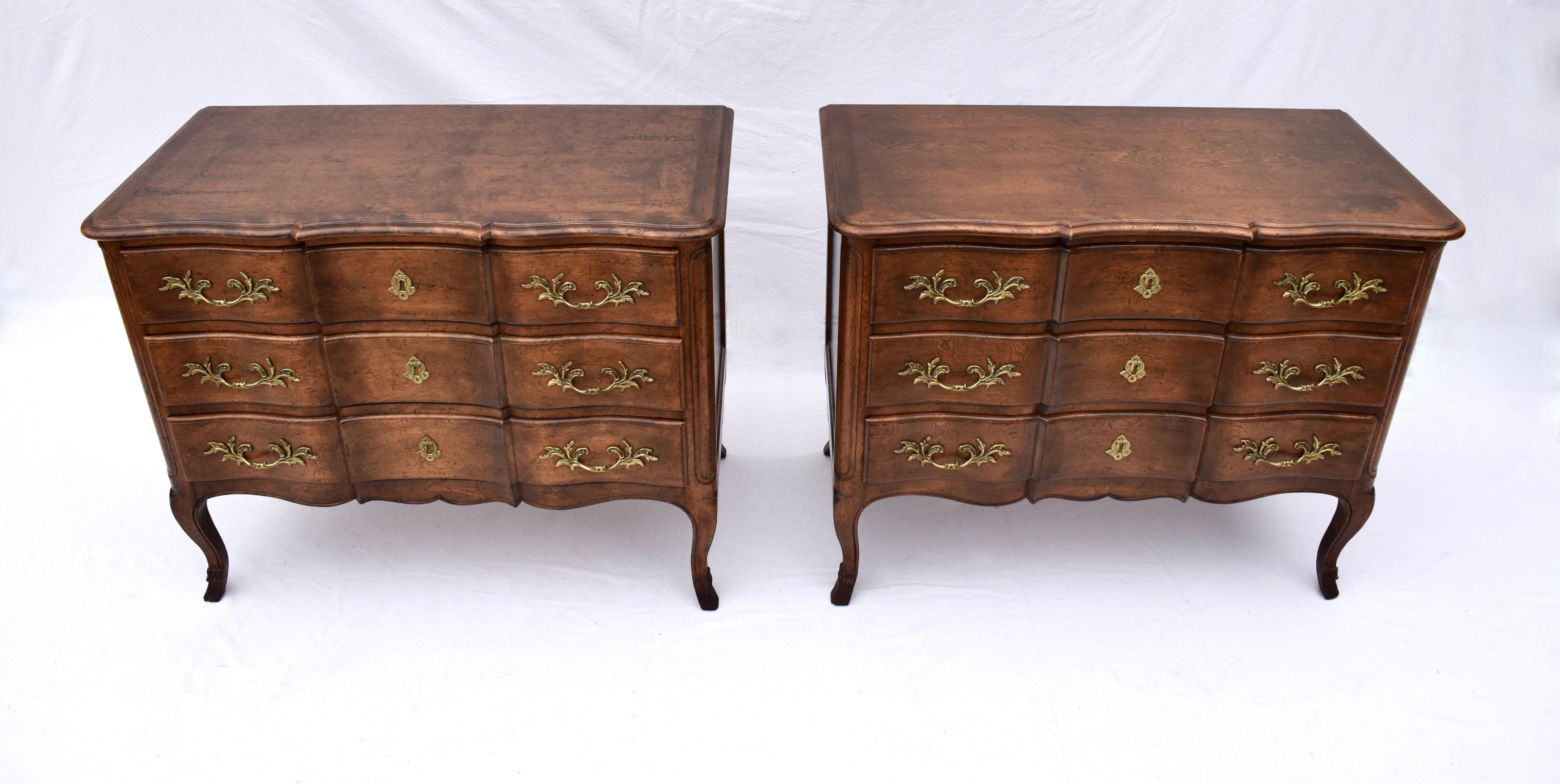 French Country style matching commodes with serpentine block fronts and conforming tops, surmounting three generous size drawers and original hardware. Splayed legs are finished with marvelous hooves feet typically seen in period examples of French