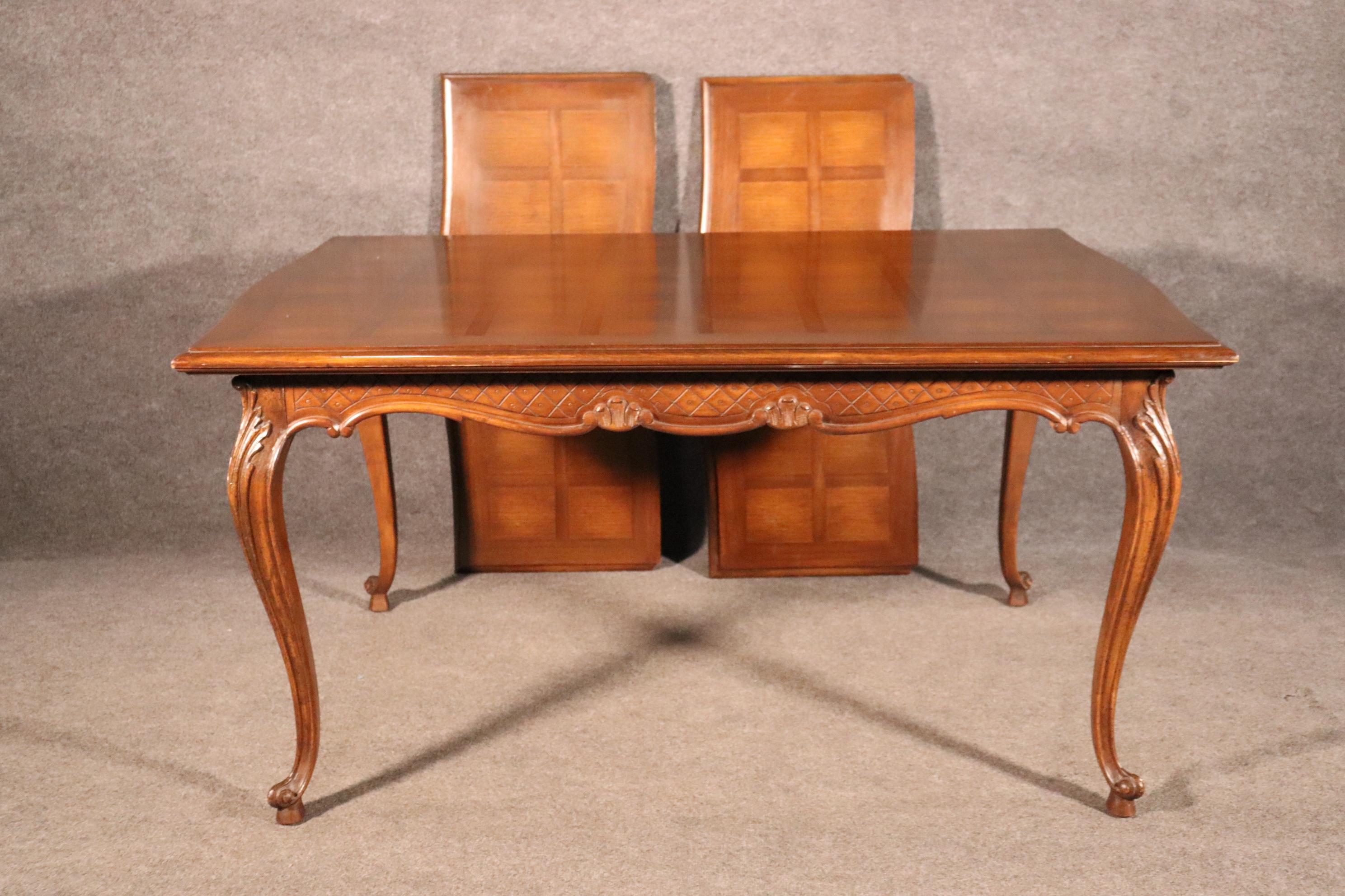 This is a charming French country or Louis XV dining table with two leaves. The table is made of walnut and is in good condition with minor signs of age related wear and signs of use. The table measures 42 wide x 59 long x 30 tall. The leaves each