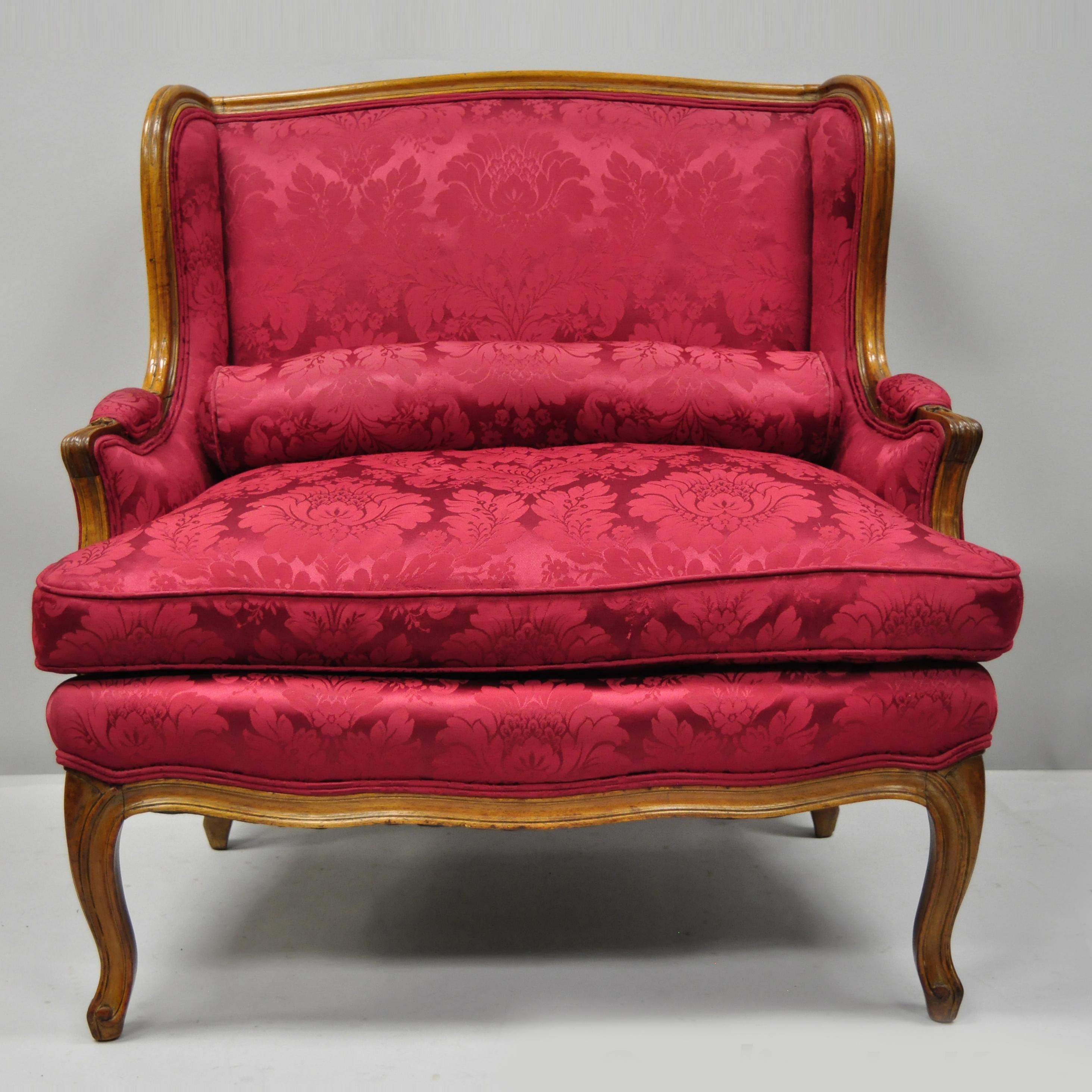 Antique French Country Louis XV style carved mahogany settee. Item features partial down filled cushion, bolster pillow, solid wood construction, and cabriole legs, circa 1950. Measurements: 36