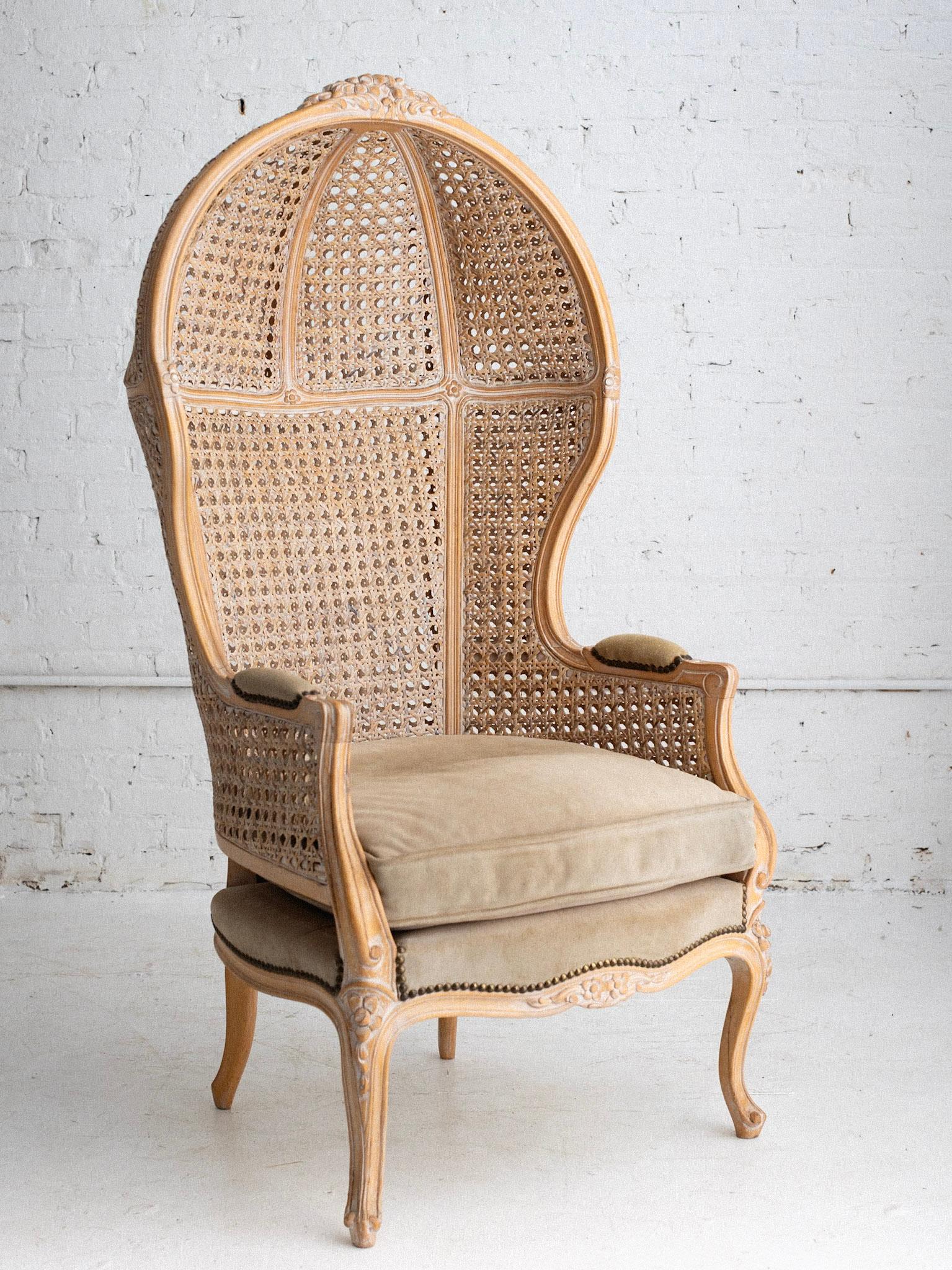 A mid century Louis XV style porter chair. Balloon canopy silhouette with double cane paneling. White washed blonde oak frame and original gray suede upholstery.