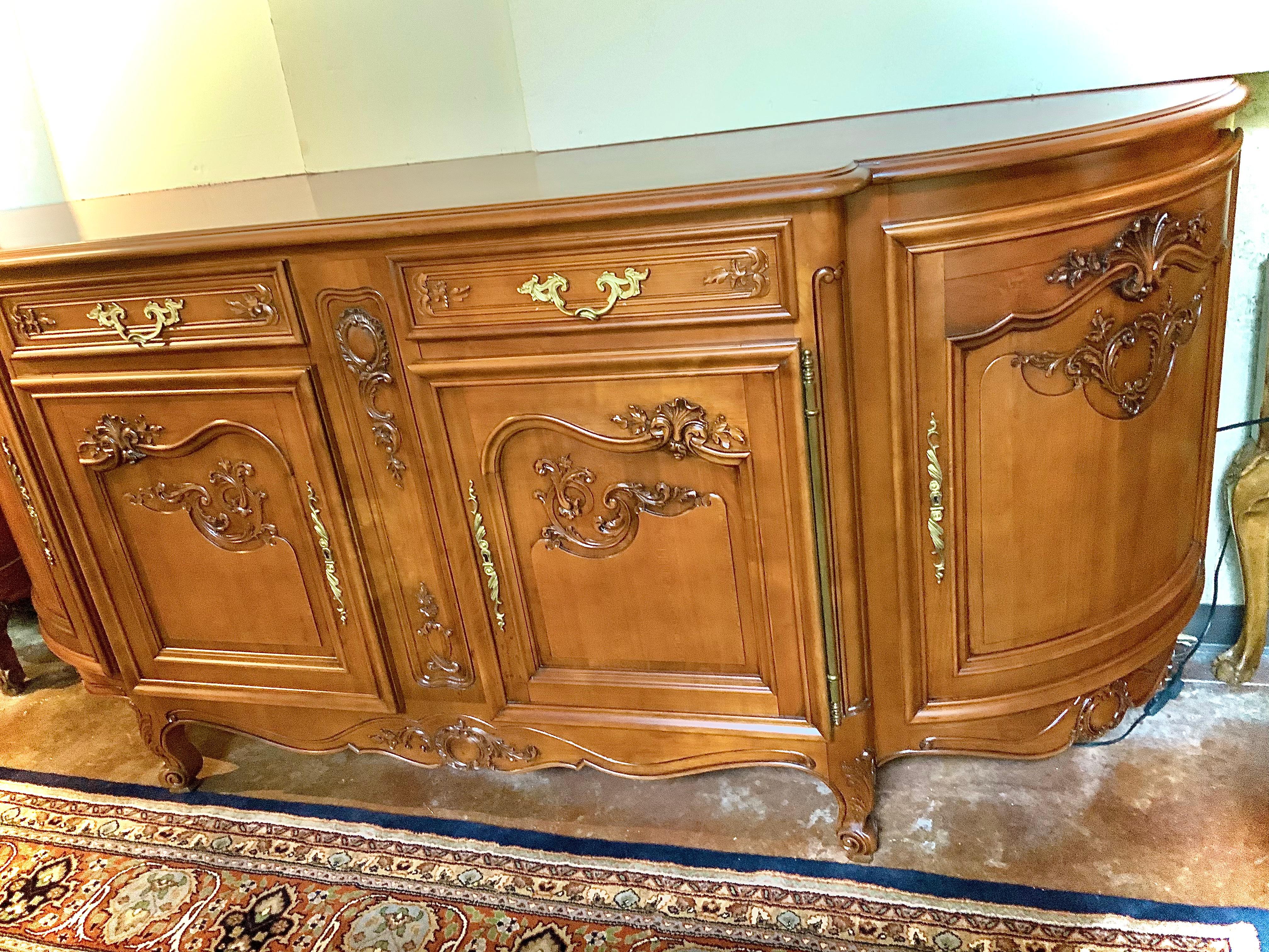 This fine buffet/sideboard is fitted with two centered drawers over two cabinet doors, 
Flanked by curved door side cabinets, interior shelf, rising on cabriole legs that are
Beautifully carved ending in whorl feet. This cabinet has doors that