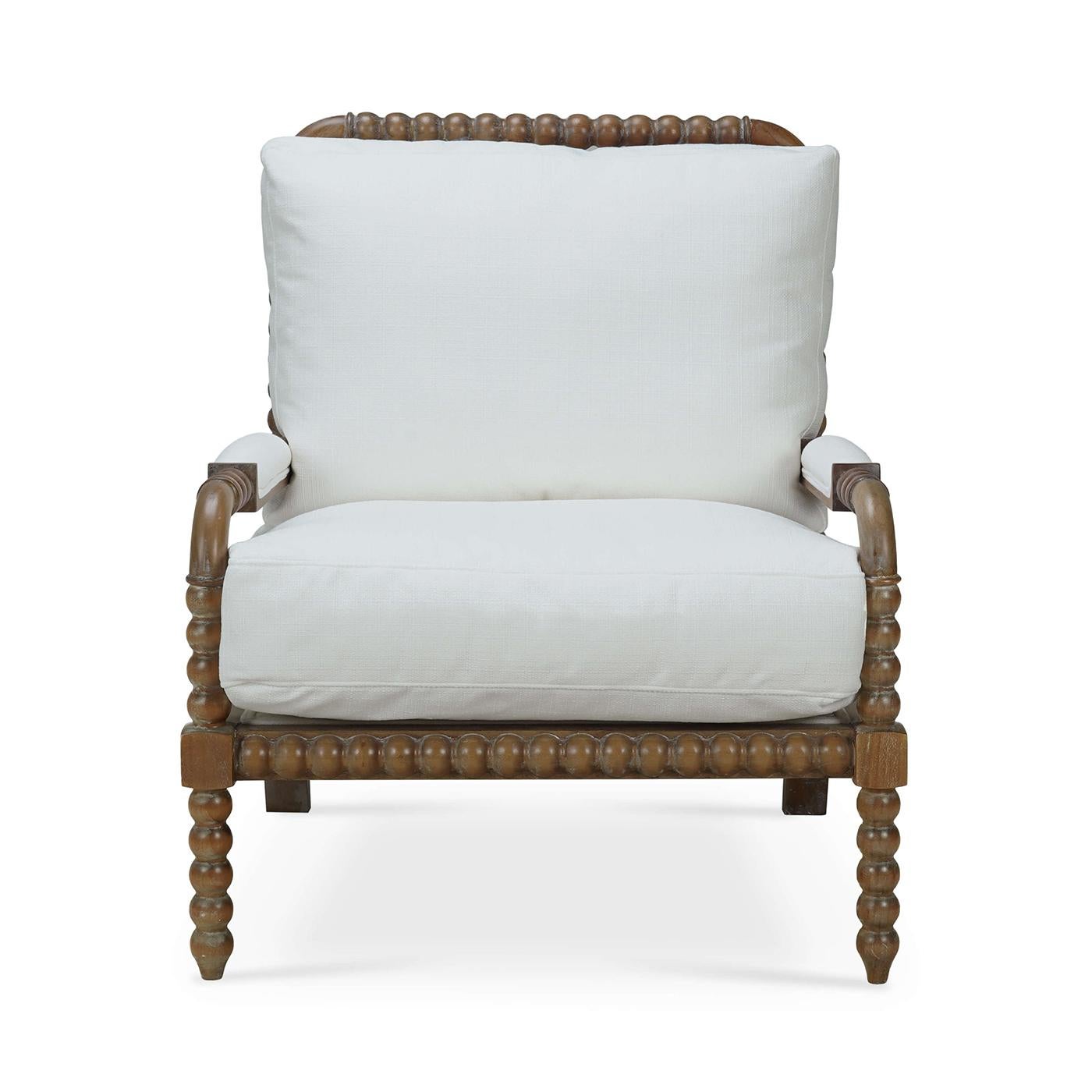A perfect blend of traditional elegance and modern comfort. This charming armchair features a unique bobbin frame finished in a straw wash finish, adding a touch of classic French country style to any room. The plush cushions are upholstered in