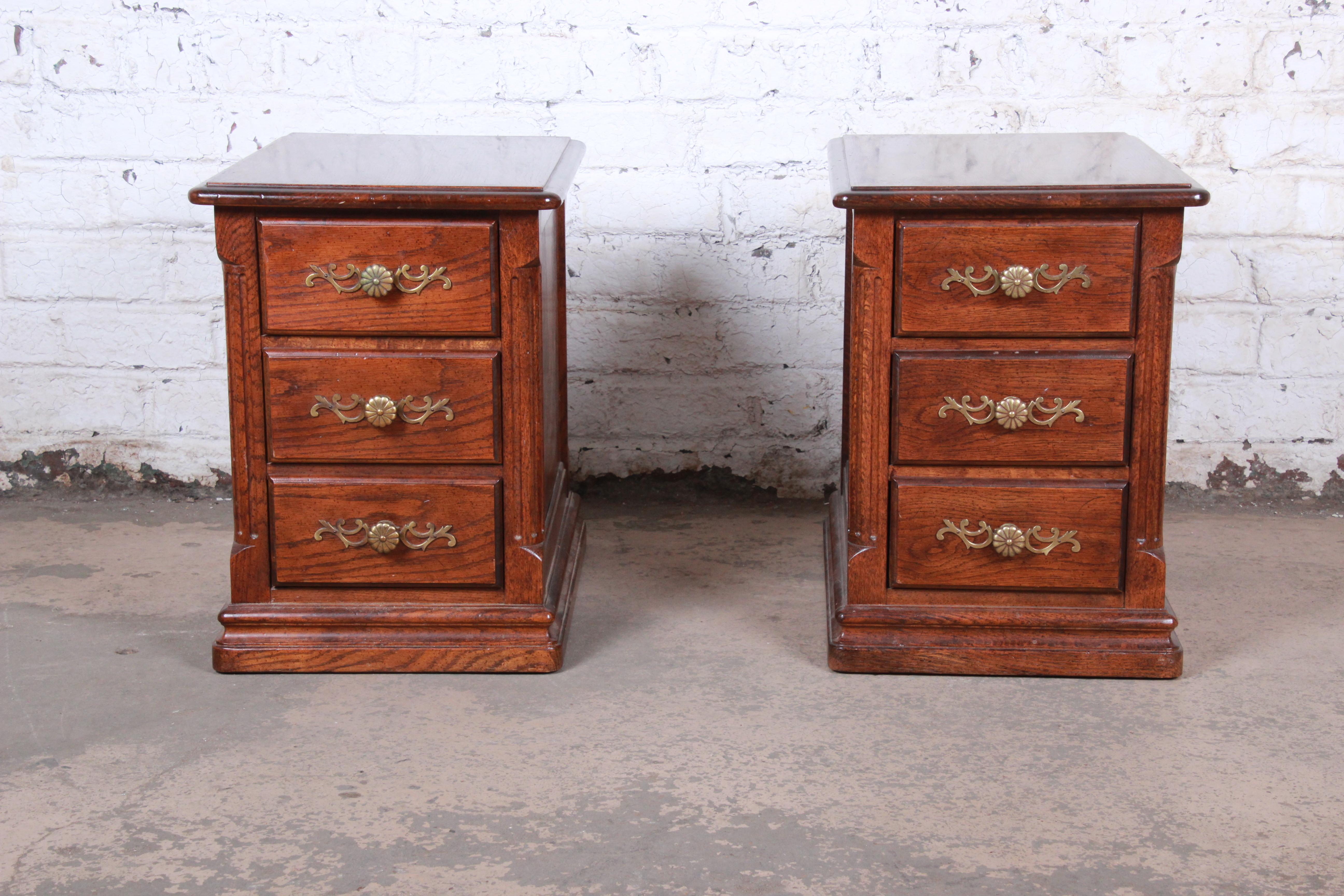 A gorgeous pair of French Provincial oak three-drawer nightstands or side tables

By Hickory Manufacturing Co.

USA, 1970s

Oak and brass

Measures: 16