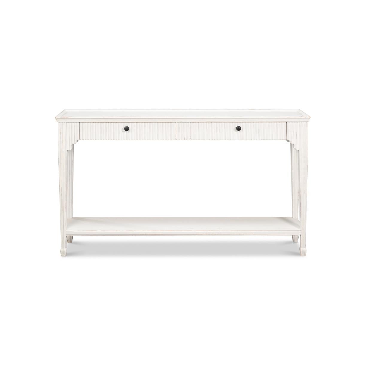 Dotée d'une finition gracieusement vieillie White Bungalow, cette élégante console incarne la sophistication européenne vintage. Les façades de tiroirs cannelées et les pieds fuselés, le plateau rectangulaire et les subtils détails sculptés