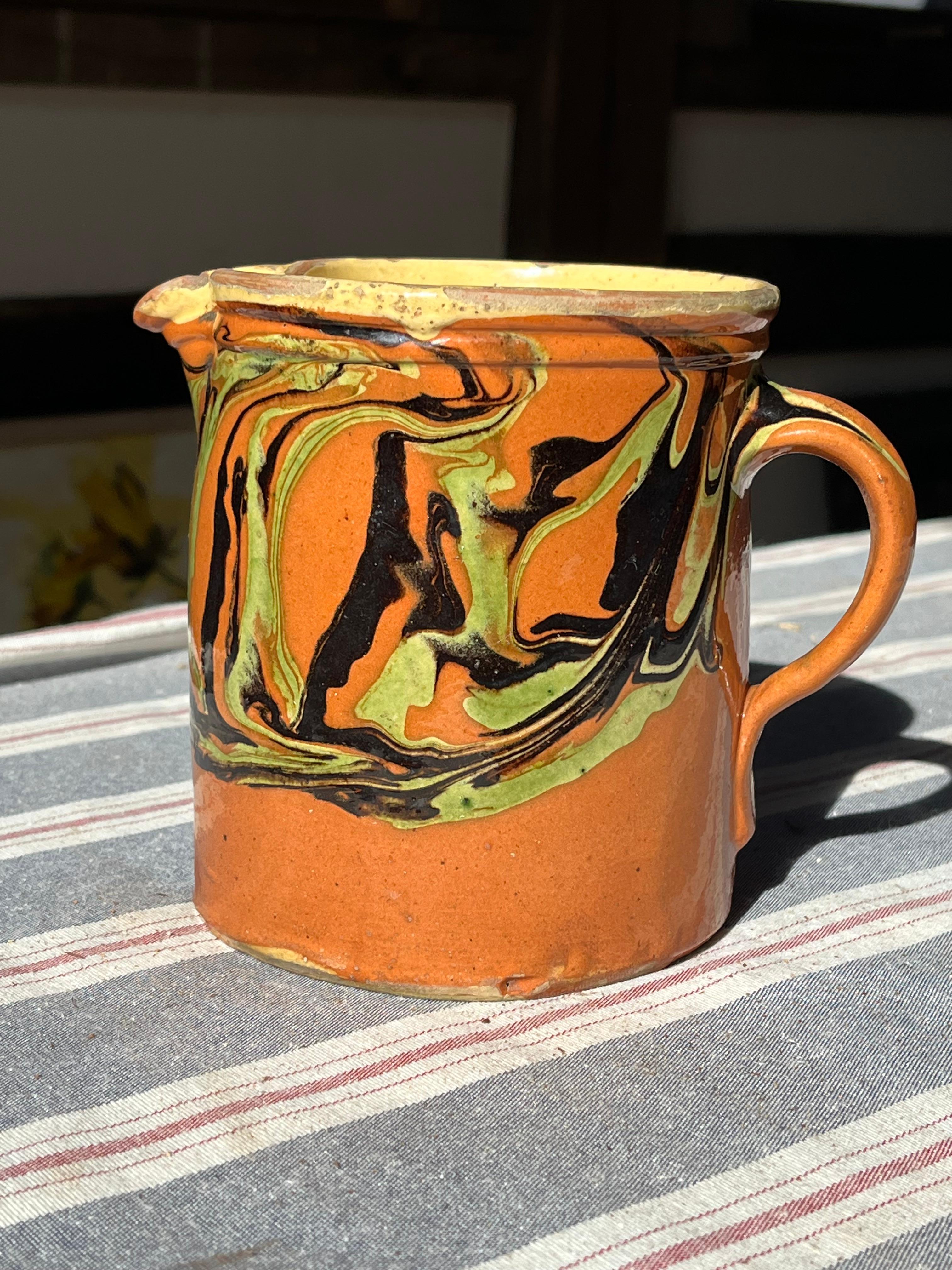 A French faience Jaspe pitcher from the Savoie region, brown glaze with green and black glaze decoration, circa 1890.