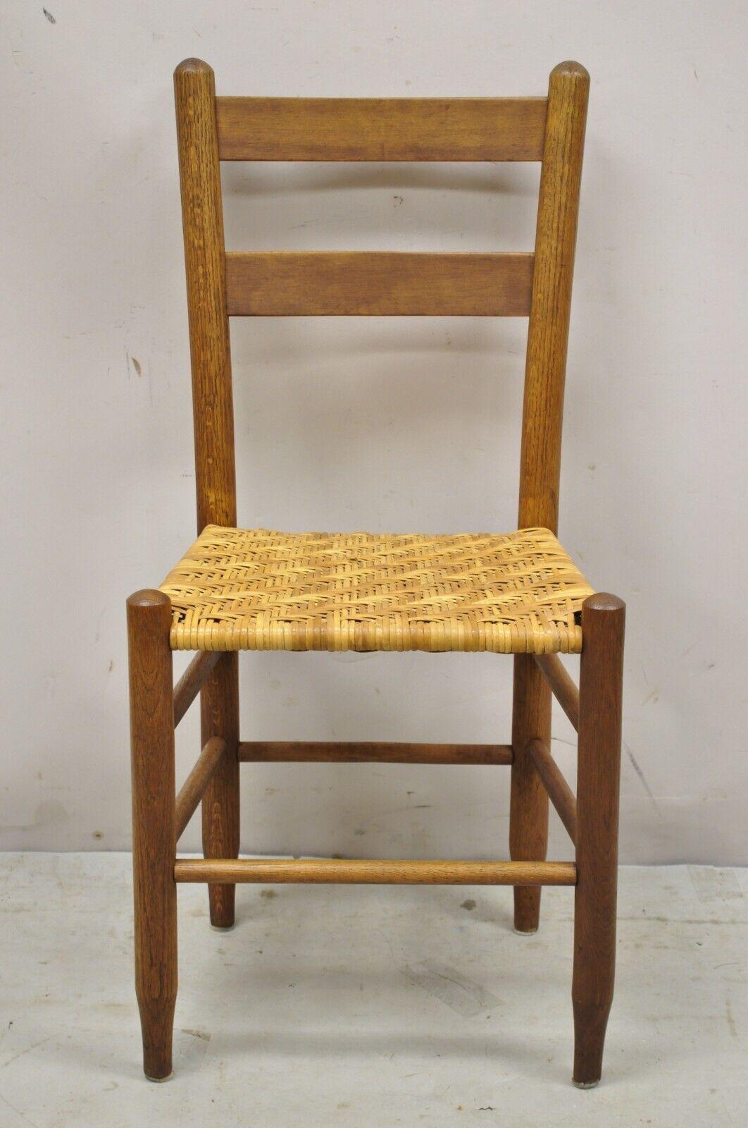 Vintage French country primitive oak ladderback small rattan dining chairs - set of 4. Item features woven rattan seats, nice smaller size, solid wood construction, beautiful wood grain, quality American craftsmanship, great style and form. circa