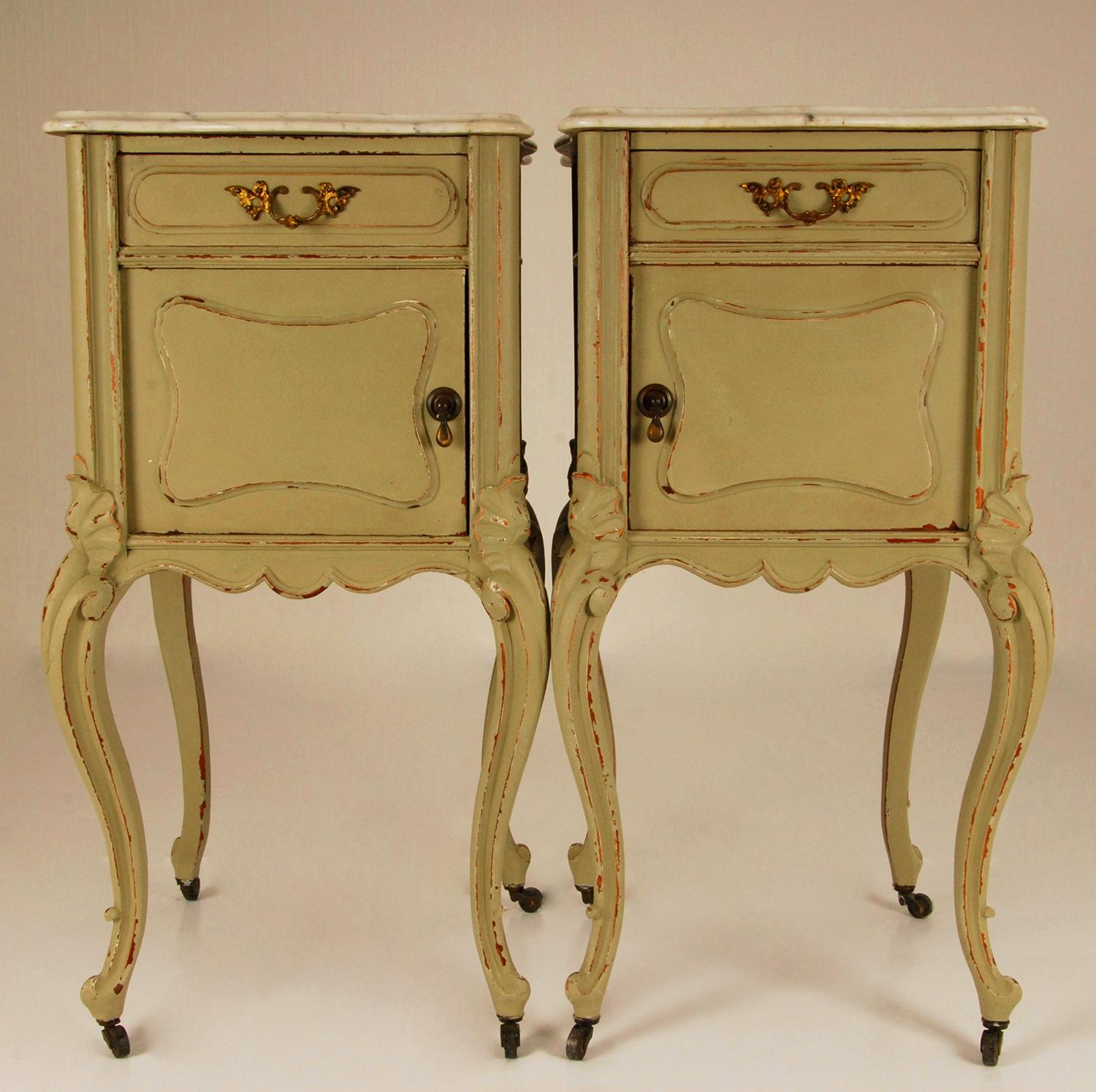 A pair French Victorian marble top nightstands on metal castors. 
Distressed painted in green with a gray vained white carrara marble top. 
Made of carved wood.
To be dated: late 19th century Napoleon III period.
Origin: France
Condition good: