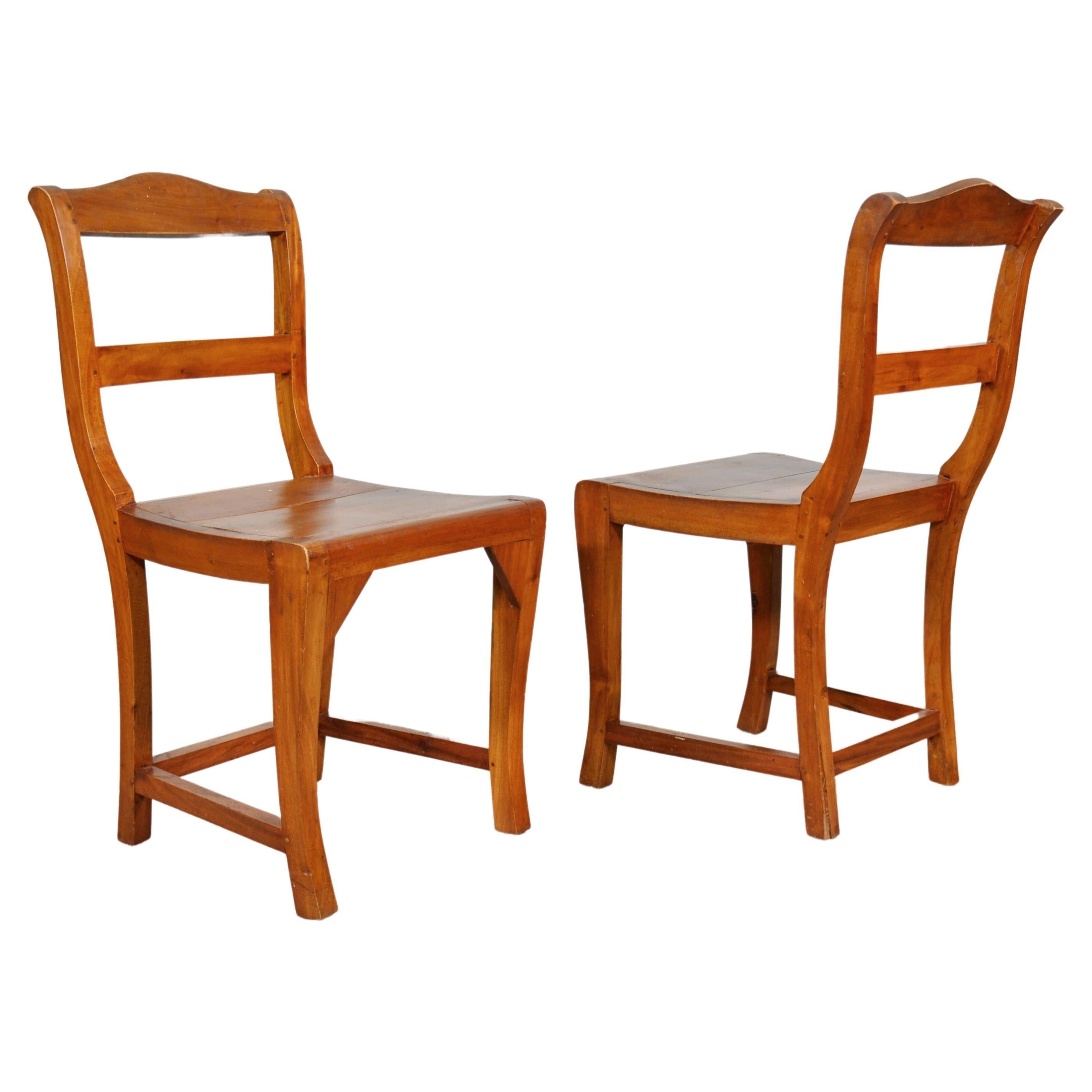 Unusual pair of antique hand-crafted shaped ladder back chairs made from fruitwood. Circa 1880. Ideal for use in a hall / mud room. Rustic French country look that works equally well in a beach house, a farmhouse or a mountain ski resort chalet.