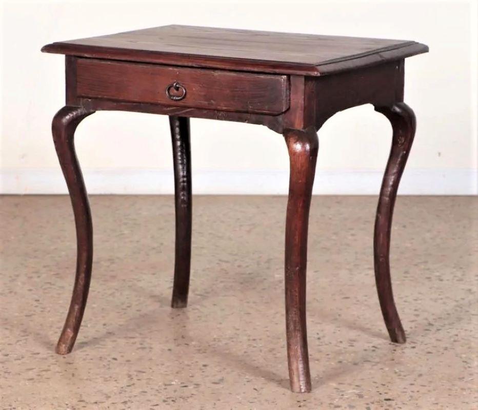 A charming Louis XV period side table in stained oak, with a single drawer on cabriole legs, circa 1760. The drawer has a nice old iron ring pull and the piece has a lovely old patina. Slightly rustic but refined.