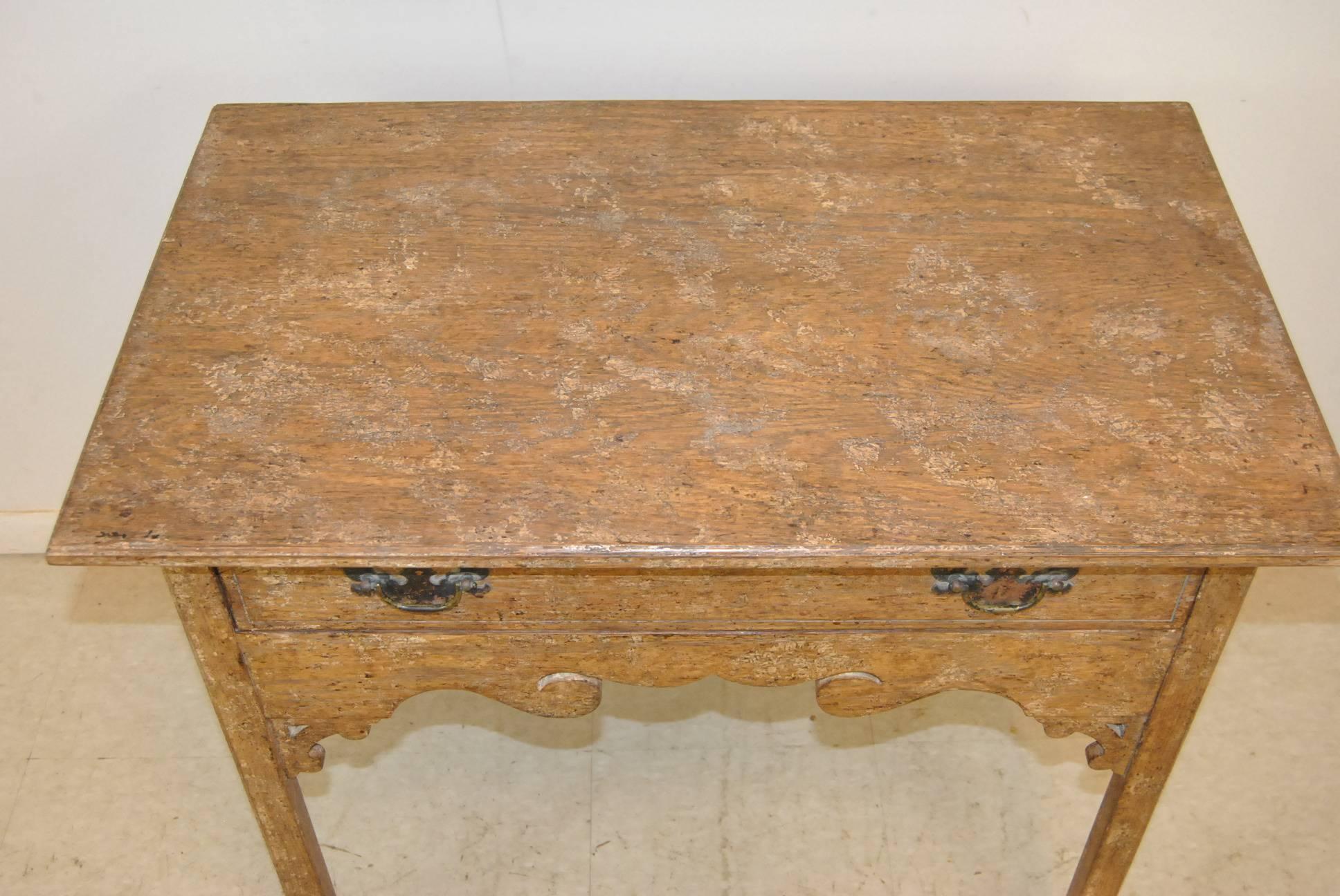 A beautiful French Country single drawer stand by Isenhour. This stand features a heavy distressed old paint finish on oak, brass hardware and a nice cut out skirt. Excellent condition. The dimensions are 31.5