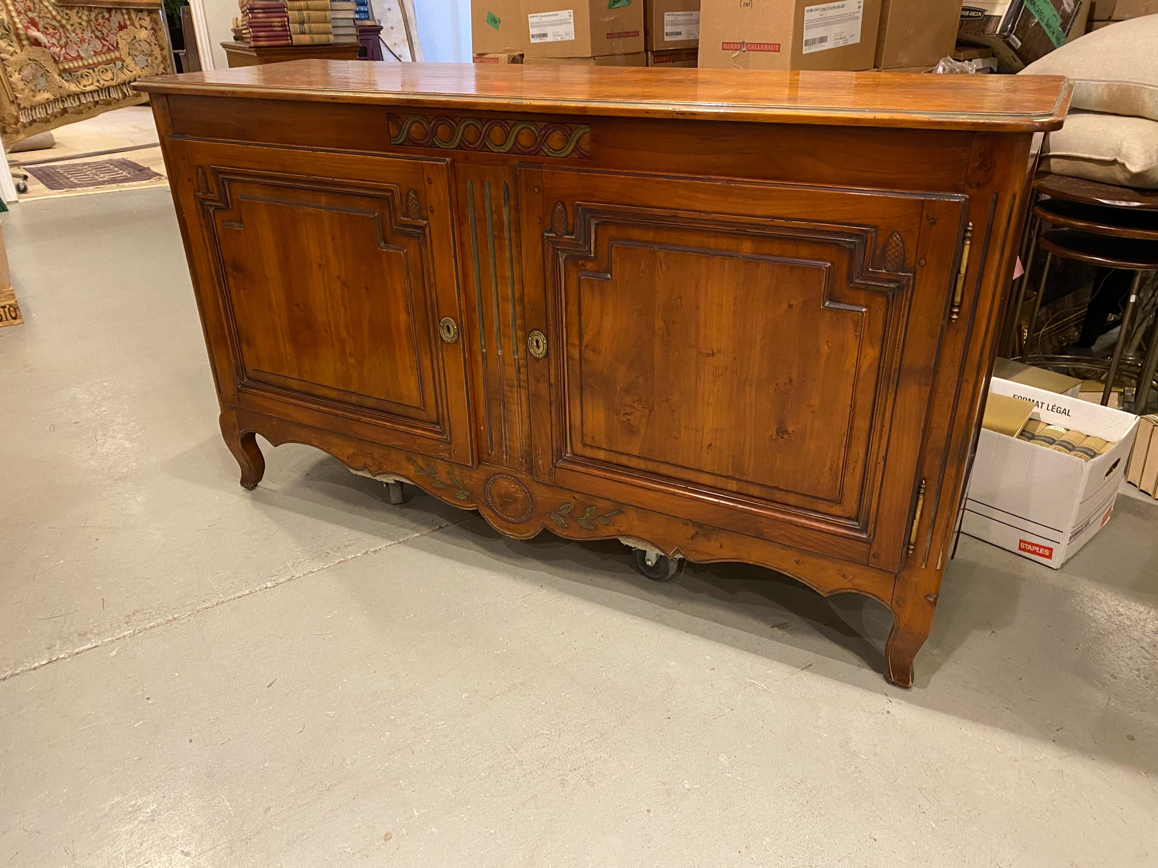 A lovely two door hand crafted French buffet sideboard with concealed drawer. This sideboard crafted in solid cherry is a quality piece finished in warm ochre brown cherry stain with a subtle accent of green as seen in the photos. The carving in the