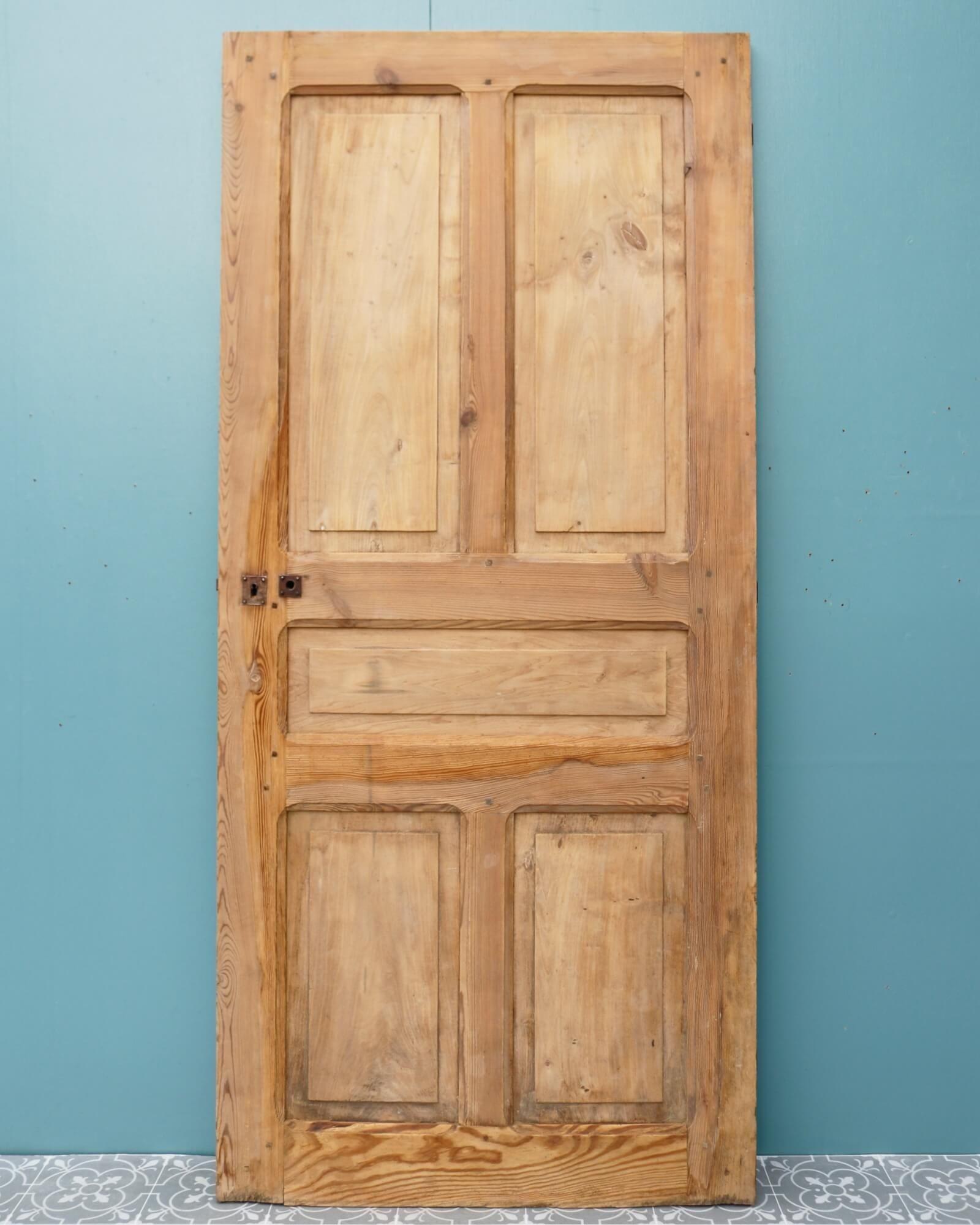 Dating from the 1870s, this French country style interior door looks beautiful in a country kitchen or rustic farmhouse setting. It is made in pine with walnut panels and has a stripped finish, highlighting the natural woodgrain and characterful