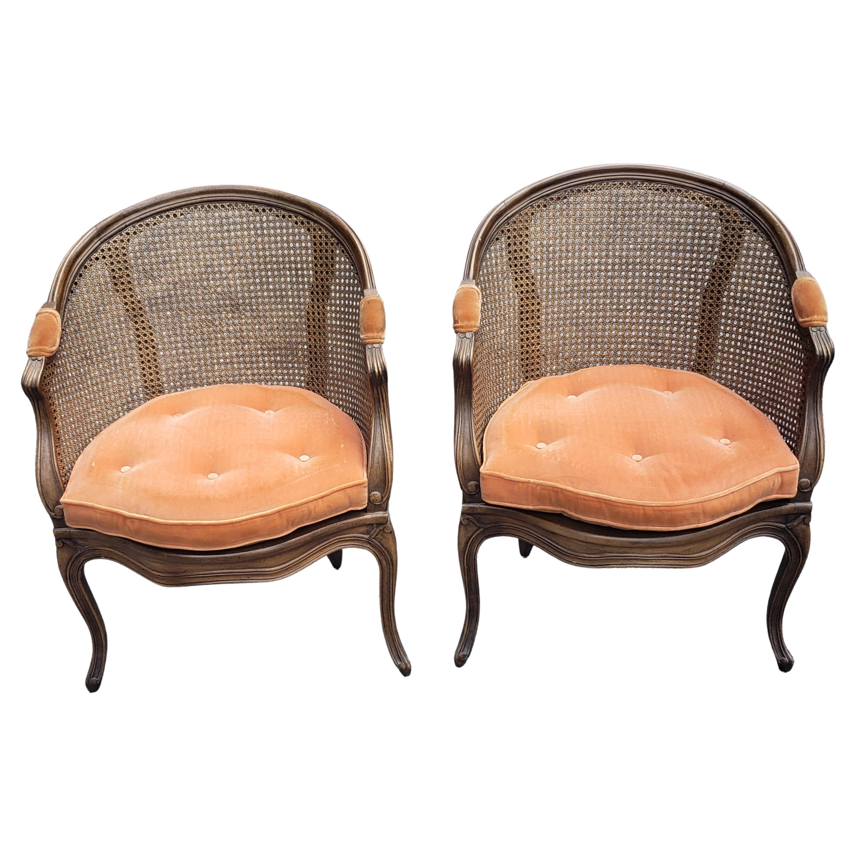 Pair of French provincial/Country walnut and cane chairs in very good vintage condition. Double sided removable tufted seat cushion. Color peach coralish color cushions. Measures 25