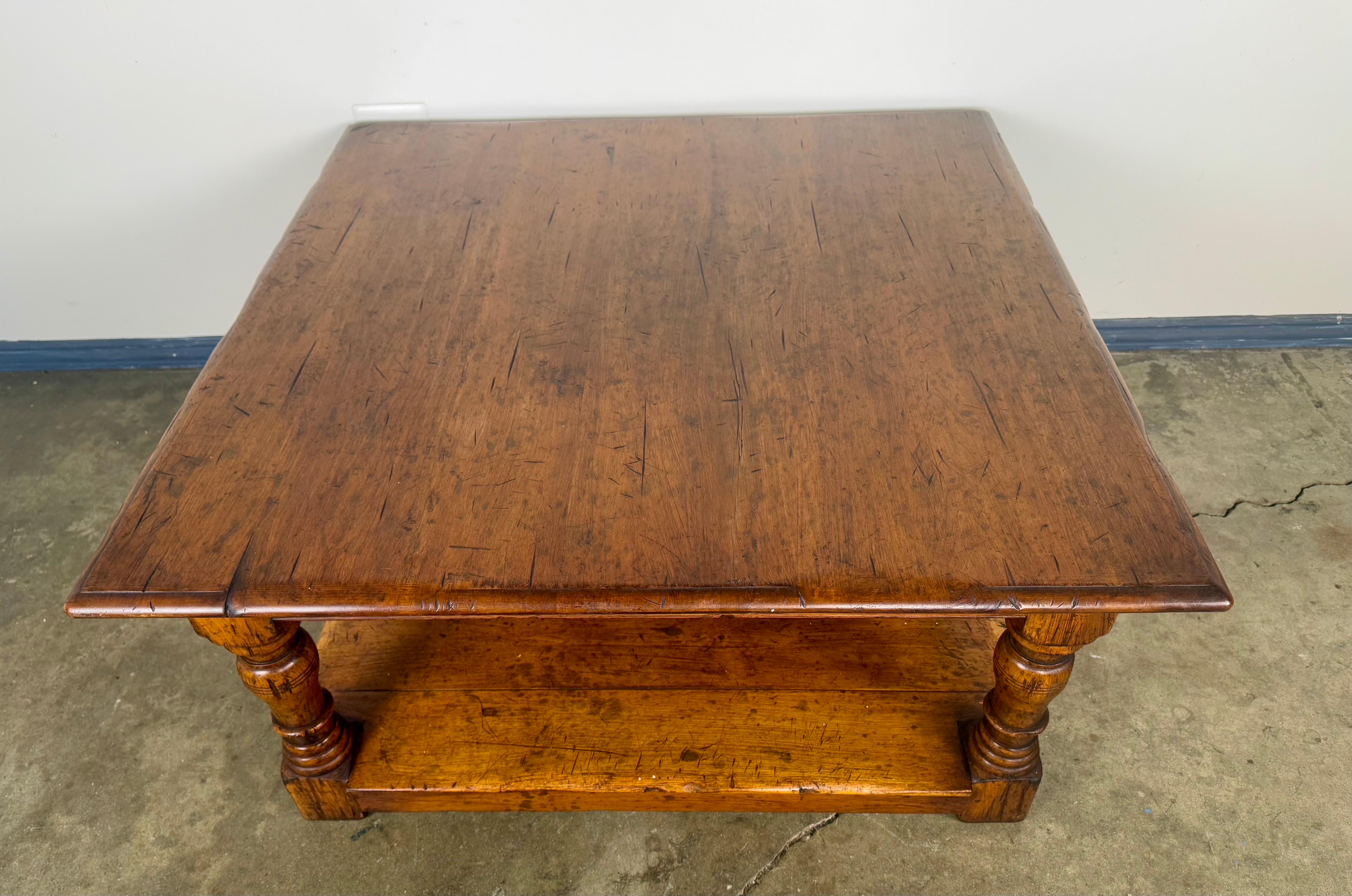 Une table basse en noyer massif magnifiquement travaillée, à la patine riche et chaude et à la forme substantielle. Le plateau rectangulaire présente le caractère naturel du bois, avec des veines visibles et une usure authentique due à l'âge qui