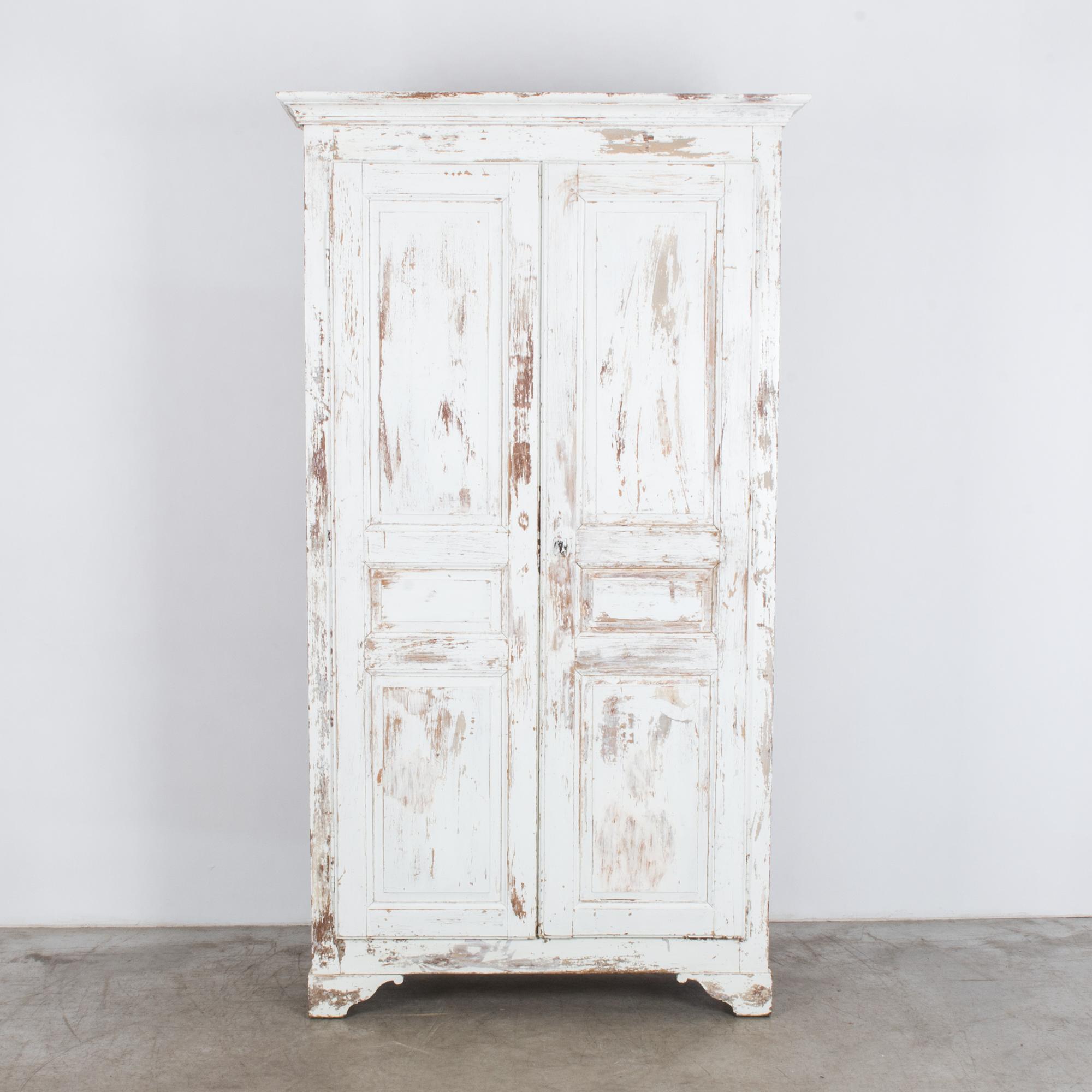 From turn of the century France, a spacious tall wardrobe with a textural white patina. Cleaned and refreshed in our atelier, this piece retains the original white paint, restored and stabilized to a time touched white tone, revealing an earlier