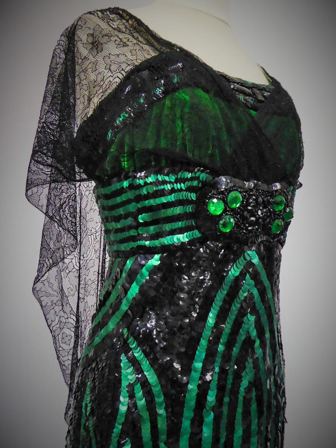Circa 1910/1920
France

Haute Couture evening gown by an anonymous designer in black tulle embroidered with emerald green and black paillons from the Art Deco period. High-waisted bustier dress and thin straps in green velvet and wide integrated