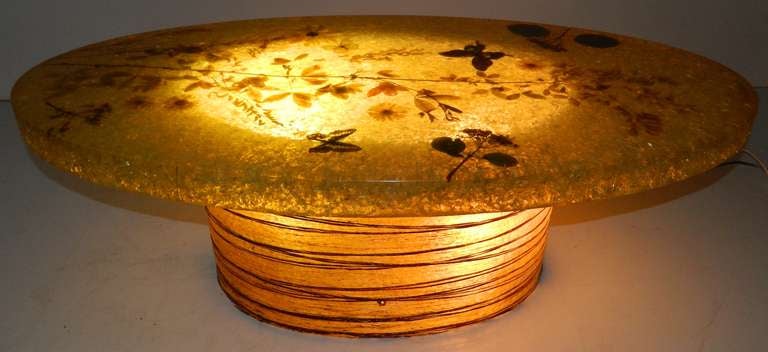 Very decorative oval coffee table manufactured by Accolay. Crackled resin with real leaves and butterflies. Grass is incorporated in the resin base.
US wired and in working condition
3 bulbs / 100w inside the base.