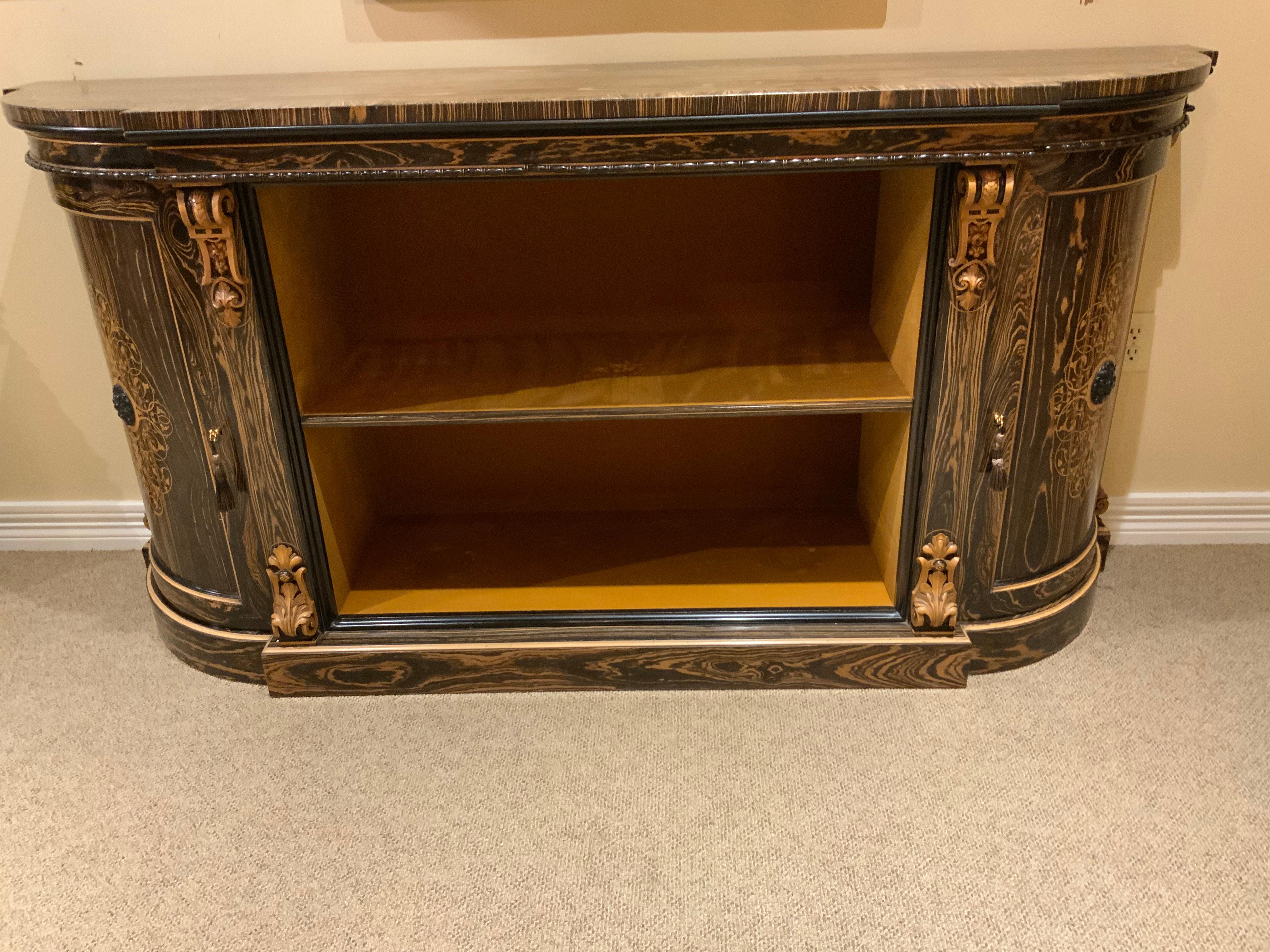 Exceptional credenza made of an exotic calamander wood with intricate satinwood inlay.
Curved side panels open for storage with each side having one shelf. The center has one
Shelf that can be moved up or down. Great as a wine cabinet or office