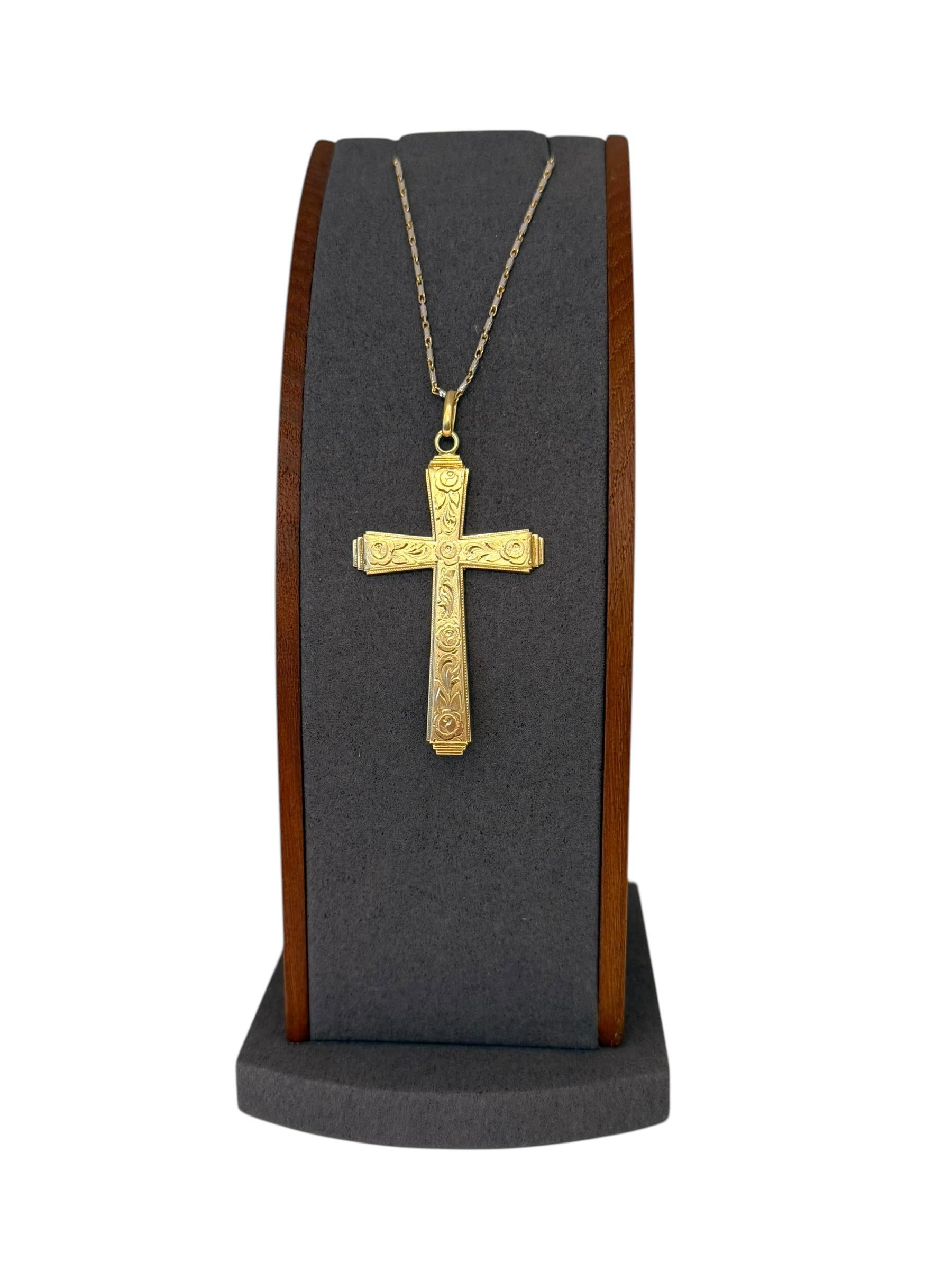 Questa elegante croce francese in oro giallo 18 carati mostra una maestria senza tempo con un delicato disegno floreale realizzato in rilievo. La superficie è satinata e crea una texture morbida e opaca che contrasta splendidamente con i motivi