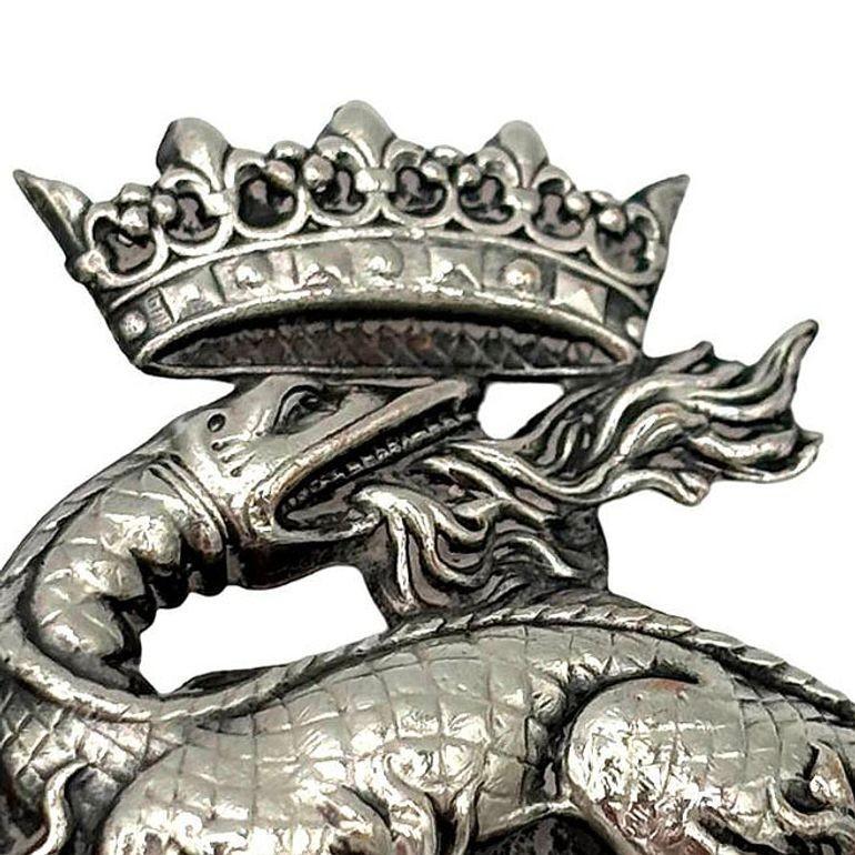 Questo ciondolo vintage a forma di salamandra coronata, realizzato in argento intorno al 1900, incarna l'eleganza del design francese ispirato alla monarchia. La salamandra, simbolo storico di coraggio e resilienza, è coronata con finezza regale e