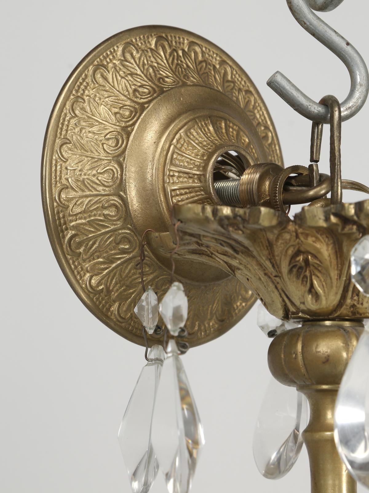 Questo lampadario vintage in cristallo francese è stato recentemente rimosso da un palazzo della Gold Coast di Chicago e, purtroppo, non ne conosciamo la storia. La particolarità di questo lampadario francese sono i cammei e i vasi di vetro a forma